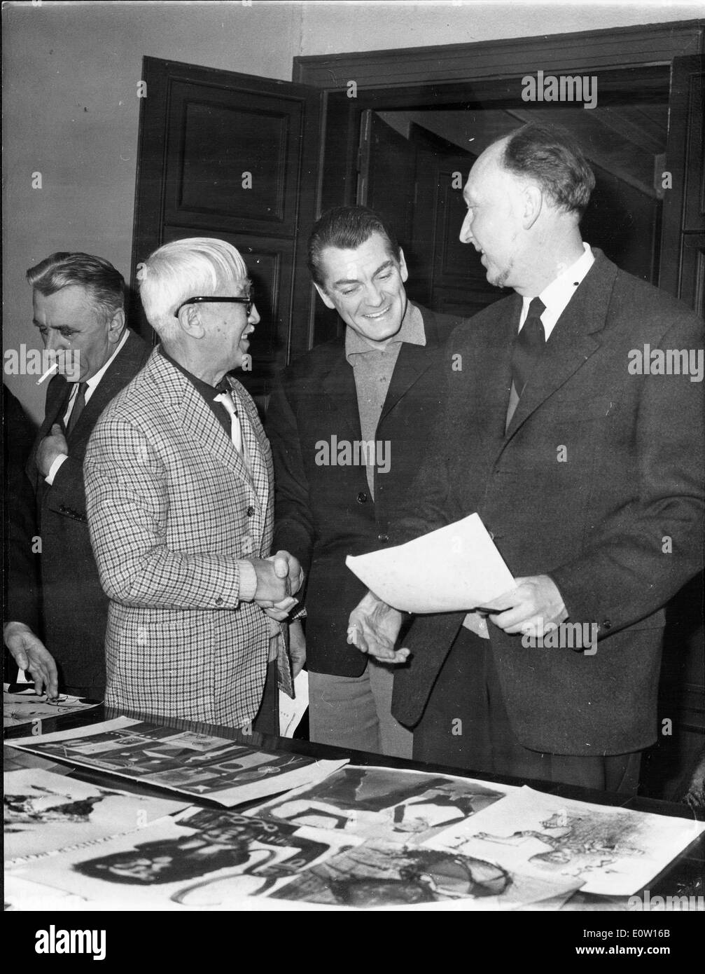 Jean Marais betrachten von Fotos mit Freunden Stockfoto