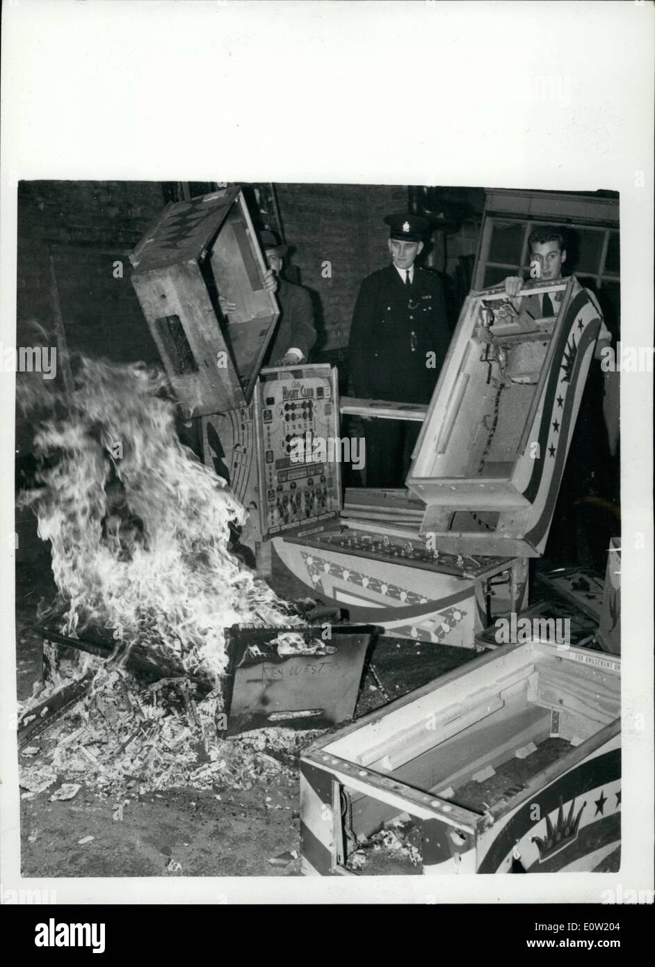 12. Dezember 1960 - Spielautomaten zerschlagen an Scotland Yards.: Beamten waren zu sehen bei Scotland Yard heute Morgen - eine Reihe von Gaming-Maschinen - die Clubs beschlagnahmt wurden zerschlagen. etc. und die sind erwies sich als illegal. Foto zeigt, dass Inspector G. Stragan überwacht die Verbrennung von der zertrümmerten Spielautomaten - in Schottland 'Hof' heute Morgen. Stockfoto