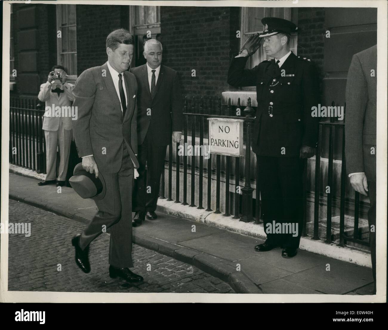 6. Juni 1961 - unscheinbare Ankunft, London: A Solitary Polizisten salutiert US Präsident John. F.Kennedy wie er angekommen Stockfoto