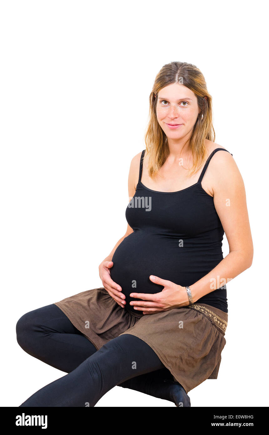 Junge schwangere Frau sitzen und Blick in die Kamera, die isoliert auf weißem Hintergrund Stockfoto