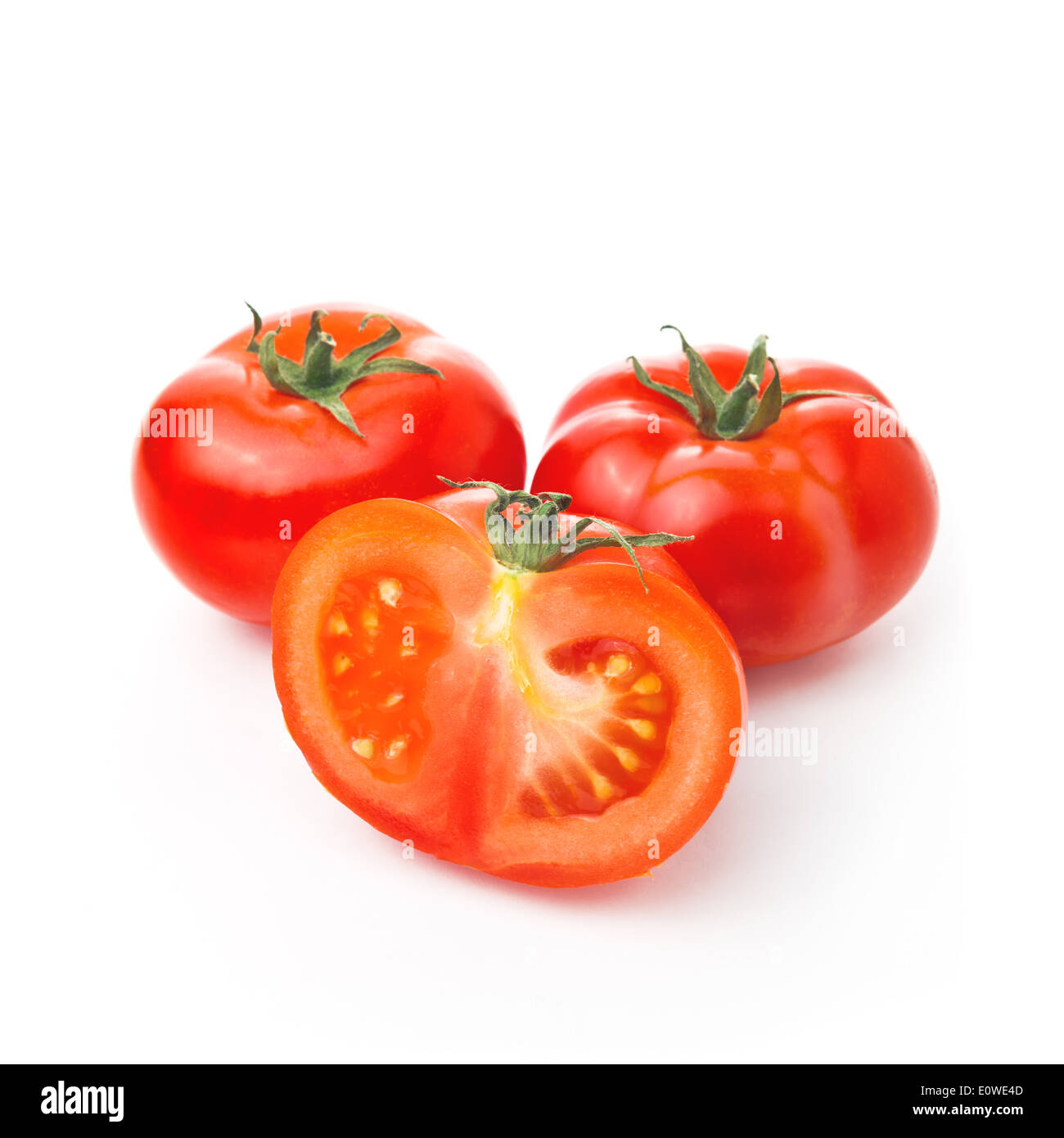 Frische rote Tomaten und eine halbe Scheibe auf weißem Hintergrund, leckere Bio-Gemüse für eine gesunde Ernährung. Stockfoto