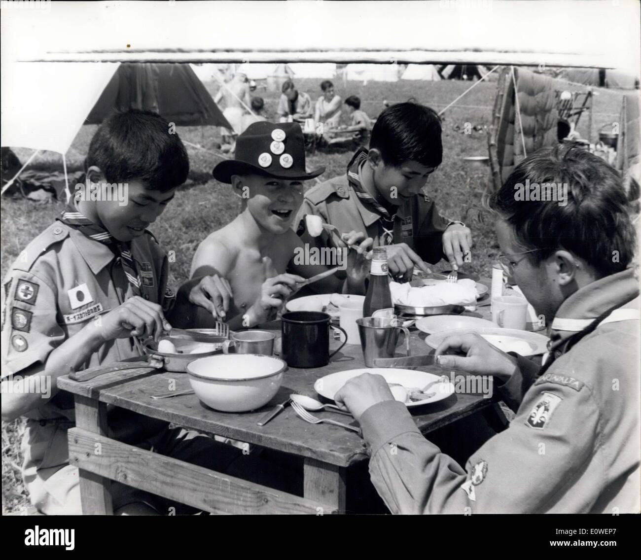 6. August 1962 - 4.000 Pfadfinder Zelten im Windsor: mehr als 4.000 Pfadfinder bilden alle Teile der Welt begann eine Woche Camp im Windsor Great Park auf Einladung der Königin. Mittagessen Sie Foto zeigt Tony Little, 11, des Lesens, zwischen zwei Japanisch Lektion in internationalen Freund. Stockfoto