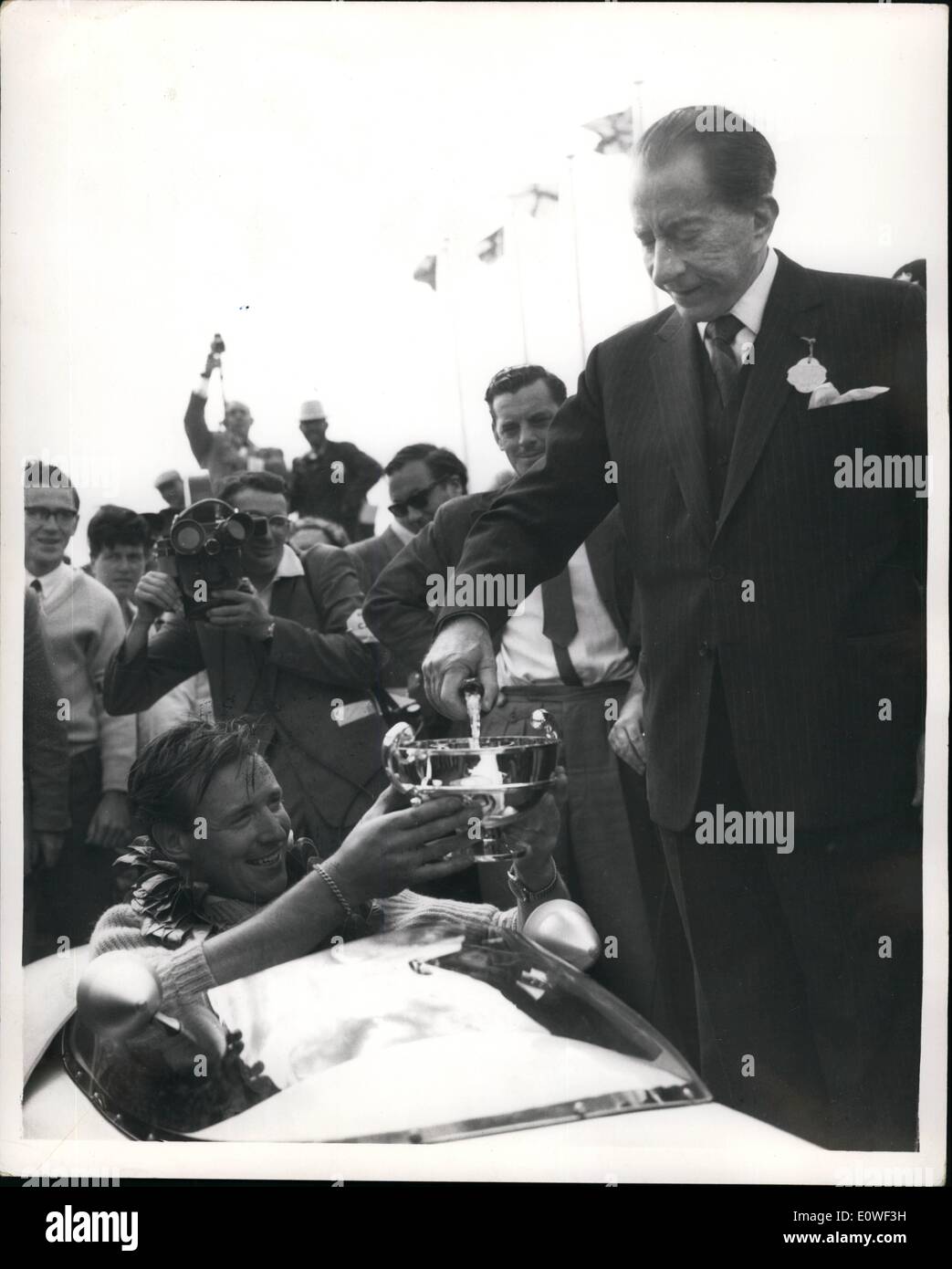 8. August 1962 - Rennsport in Goodwood. Champagner von Paul Getty: The Veadol-Meisterschaft in der R.A.C. Tourist Trophy Rennen in Goodwood gestrigen Sitzung wurde von r.c. Burnard in einem AC Bristol gewonnen. Mrs-Prize war ein Lotus Auto Millionär Paul Getty gestiftet. Foto zeigt Paul Getty Champagner für r.c. Bernard gießt, in seinem sitzt, Preis Lotus Auto nach dem Event gestern. Stockfoto