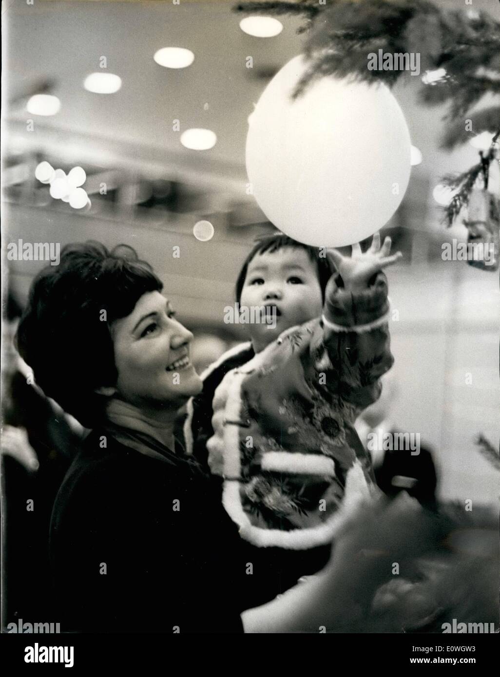 12. Dezember 1962 - ein frohes Weihnachtsfest für '' schöne Göttin ''... Kind von Gossen von Hong Kong... Neun Babys kam gestern Abend in London von der Kronkolonie Hongkong... Sie wurden hier von der International Social Service - Annahme hier von britischen Paare gekauft. Sie gerettet worden war, von den Dachrinnen und Straßen von Hong Kong - von ihren Eltern verlassen worden... Die meisten von ihnen werden neu getauft-zu befähigen, leichter mit britischen Familien passen... Keystone-Fotoshows: Ling Tai (schöne Goddess  - erreicht glücklich für eine Ballon - wie sie von Frau gehalten wird Stockfoto