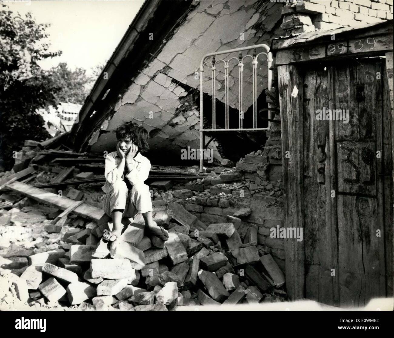 28. Juli 1963 - erste originale aus Skopje von Chris Ware genommen. Mindestens 1000 Menschen sind tot und Tausende in die Stadt Skopje Erdbeben verletzt. In der Stadt von Skopje ist die Hauptstadt von Mazedonien in Jugoslawien, die am vergangenen Freitag von einem Erdbeben heimgesucht wurde, das Zentrum der Stadt mehr als 1000 Menschen getötet und verletzt wurden Tausende mehr verwüstet. Foto zeigt ein junges Mädchen sitzt auf der Spitze ihrer zerstörten Heimat nach dem Erdbeben in Skopje. Stockfoto