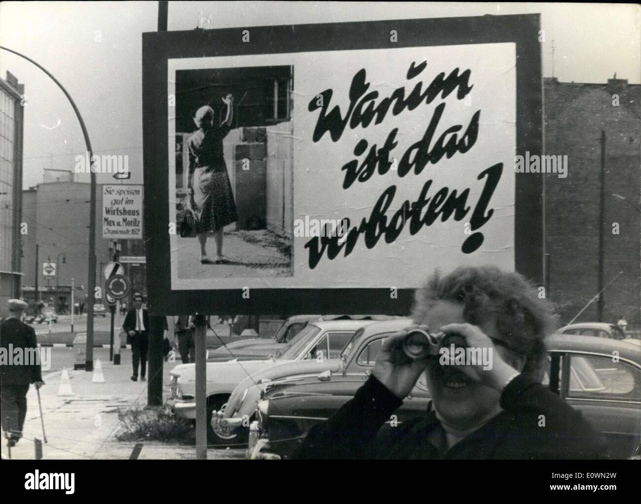 12. August 1963 - war dieses Plakat ganze über die Mauer in West-Berlin einrichten. Es macht sich lustig über die Tatsache, die der sowjetische Sektor Menschen aus, die auf der anderen Seite winken verboten hat. Diese besonderen Plakat wurde am Heinrich-Heine-Straße angezeigt. Eine alte Frau sieht in Ost-Berlin mit dem Fernglas. Stockfoto