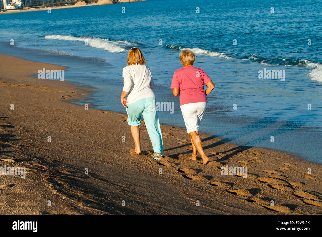 Rückansicht der Frauen in Führungspositionen am Strand joggen. Stockfoto
