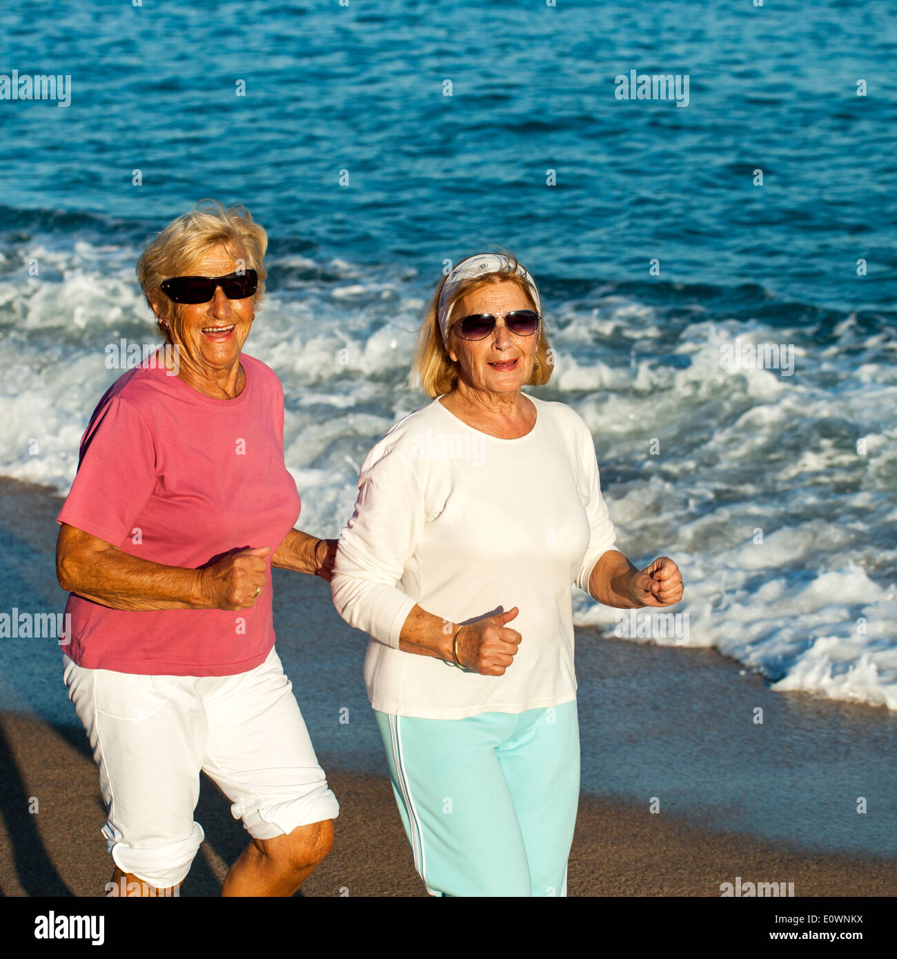 Porträt von glücklich Seniorenfitness Frauen am Strand joggen. Stockfoto