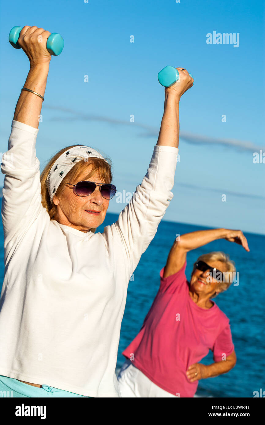 Ältere Frau Heben von Gewichten am Strand. Stockfoto