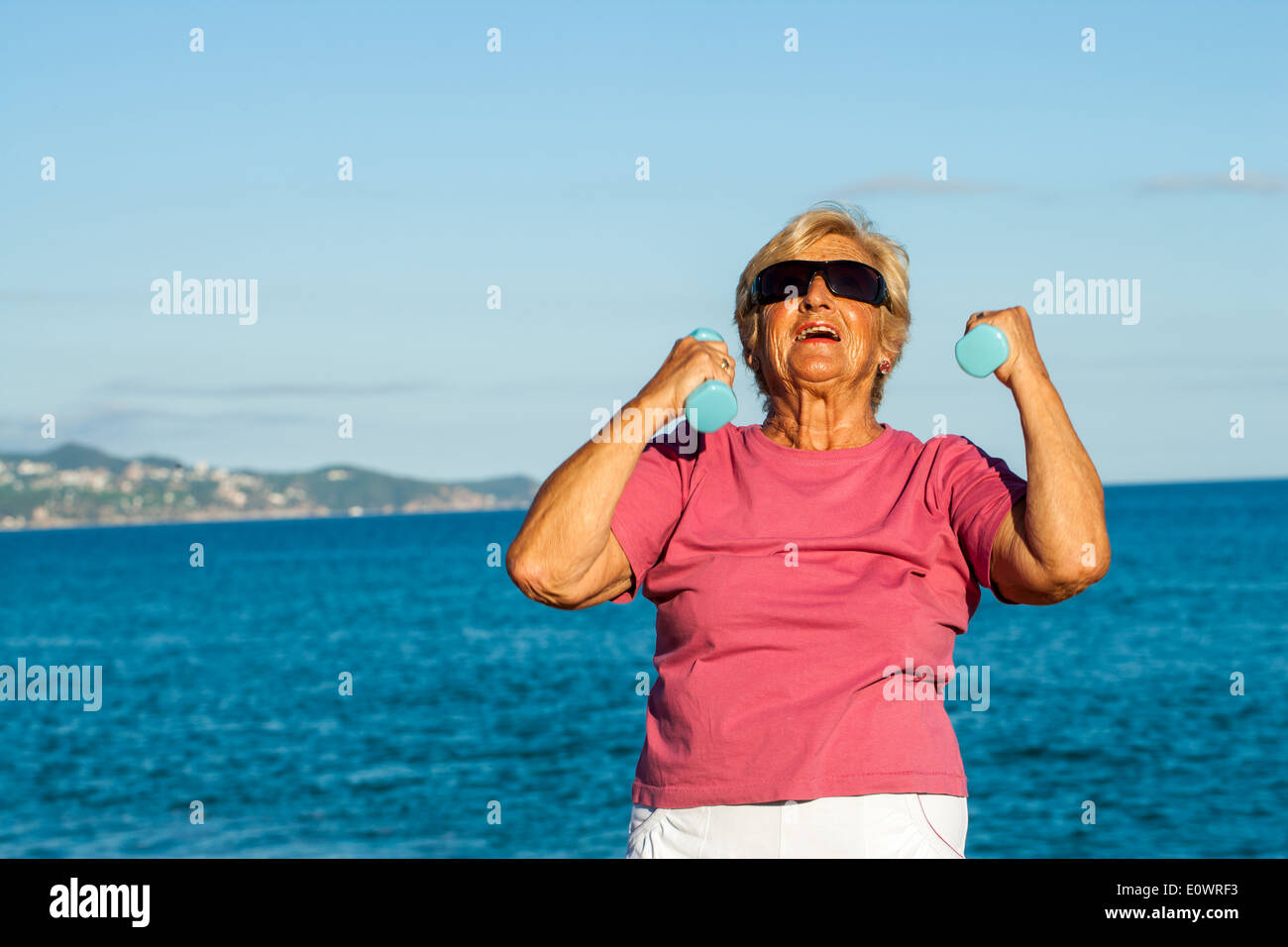 Ältere Frau kristallisiert sich am Strand. Stockfoto