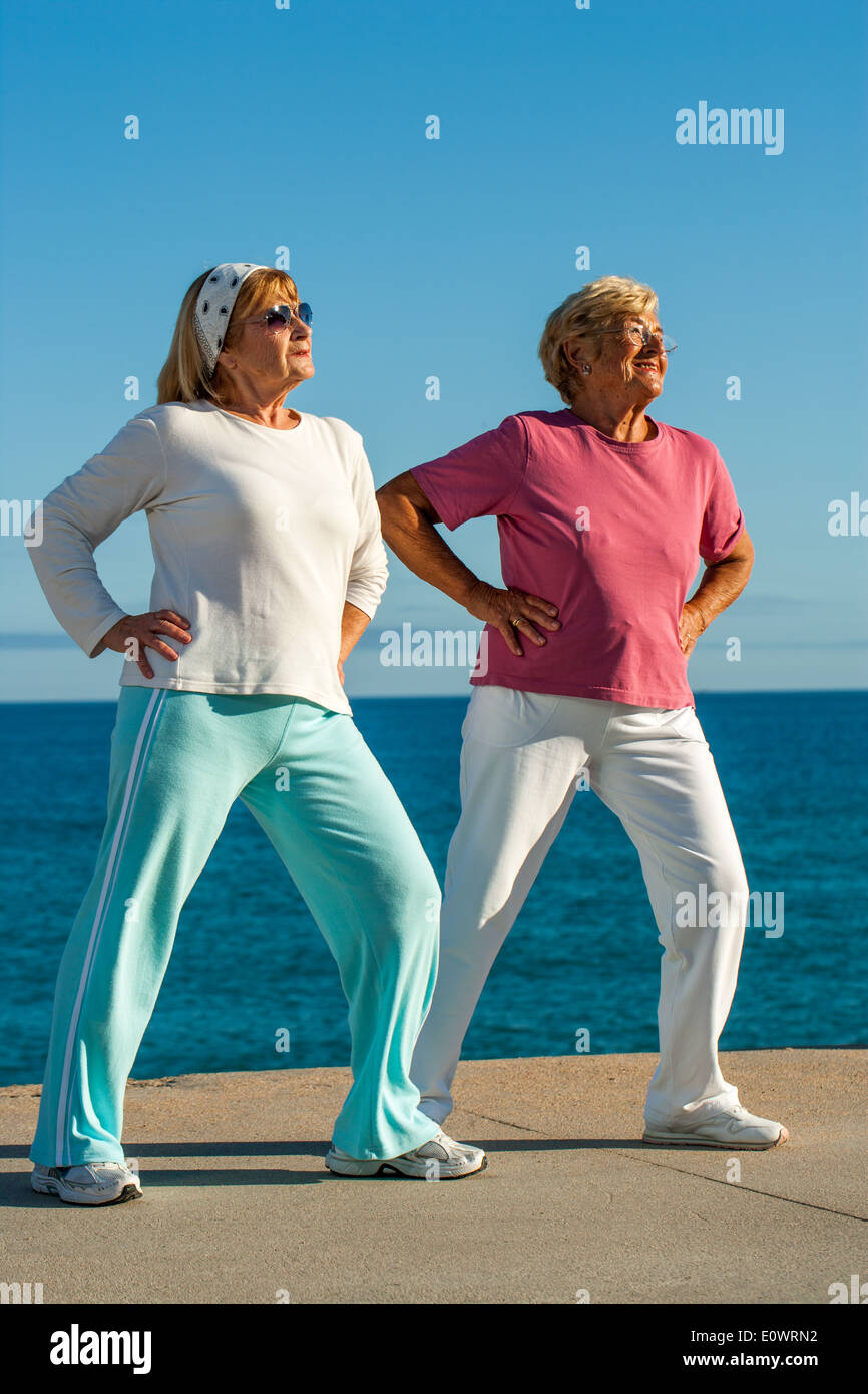 Zwei Frauen in Führungspositionen tun Bein Strecken trainieren Sie im Meer. Stockfoto