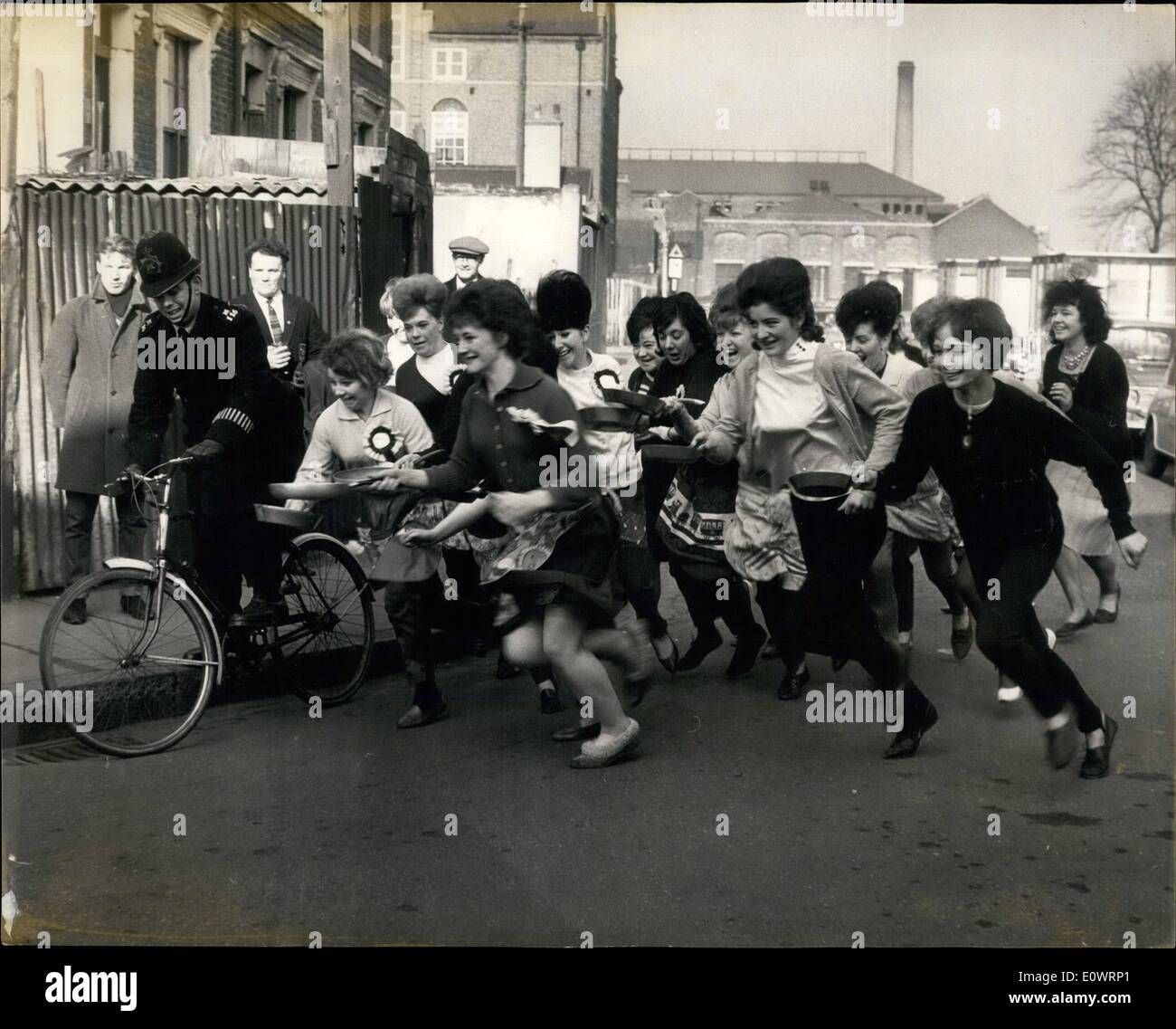 2. Februar 1964 - Pfannkuchen in der Old Kent Road racing: die jährliche Fastnacht-Rennen fand heute in der Londoner Old Kent Road, zwischen zehn Frauen, die den Prinzen von Wales Gastwirtschaft in Ruby Street und der Lord Wellington in der Old Kent Road selbst. Die Bürgermeister von Southwark und Sarmondsey stationiert waren, entlang der Route um sicherzustellen, dass die Wettbewerber ihre Pfannkuchen richtig geworfen. Foto zeigt die Teilnehmer toll aus, einen schnellen und furiosen Start, fast unter der Polizist und sein Fahrrad mitnehmen. Stockfoto