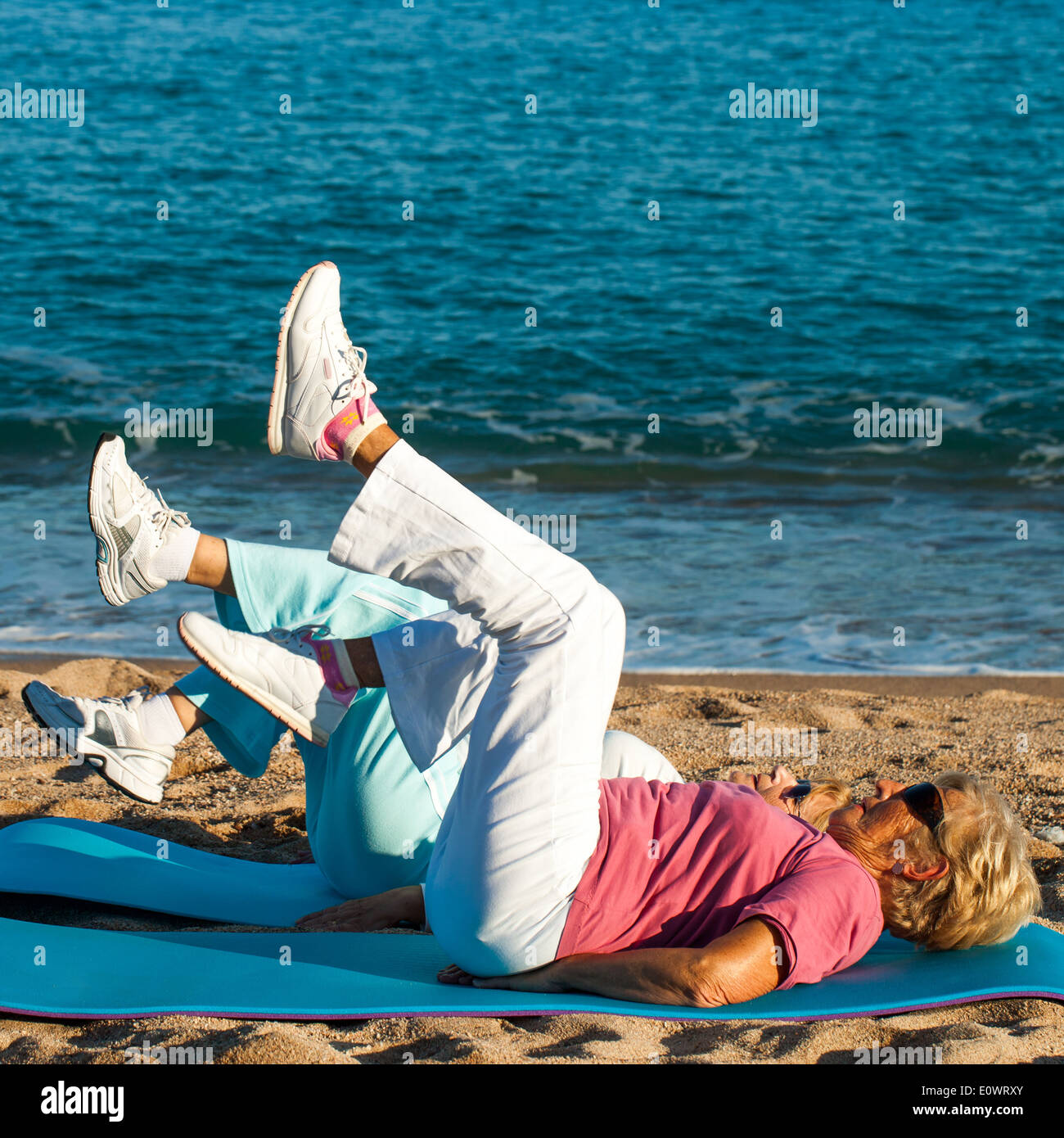 Frauen in Führungspositionen, Bein-Übungen am Strand. Stockfoto