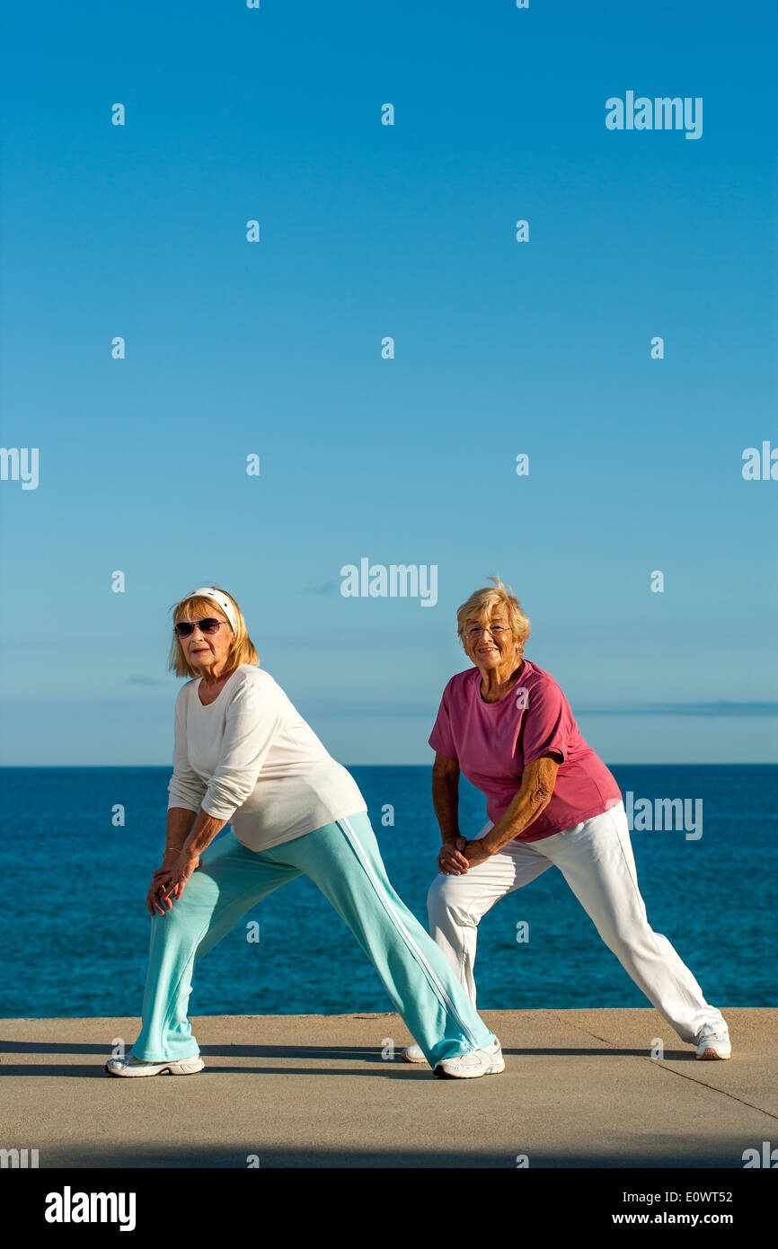 Frauen in Führungspositionen tun stretching-Übungen am Meer. Stockfoto