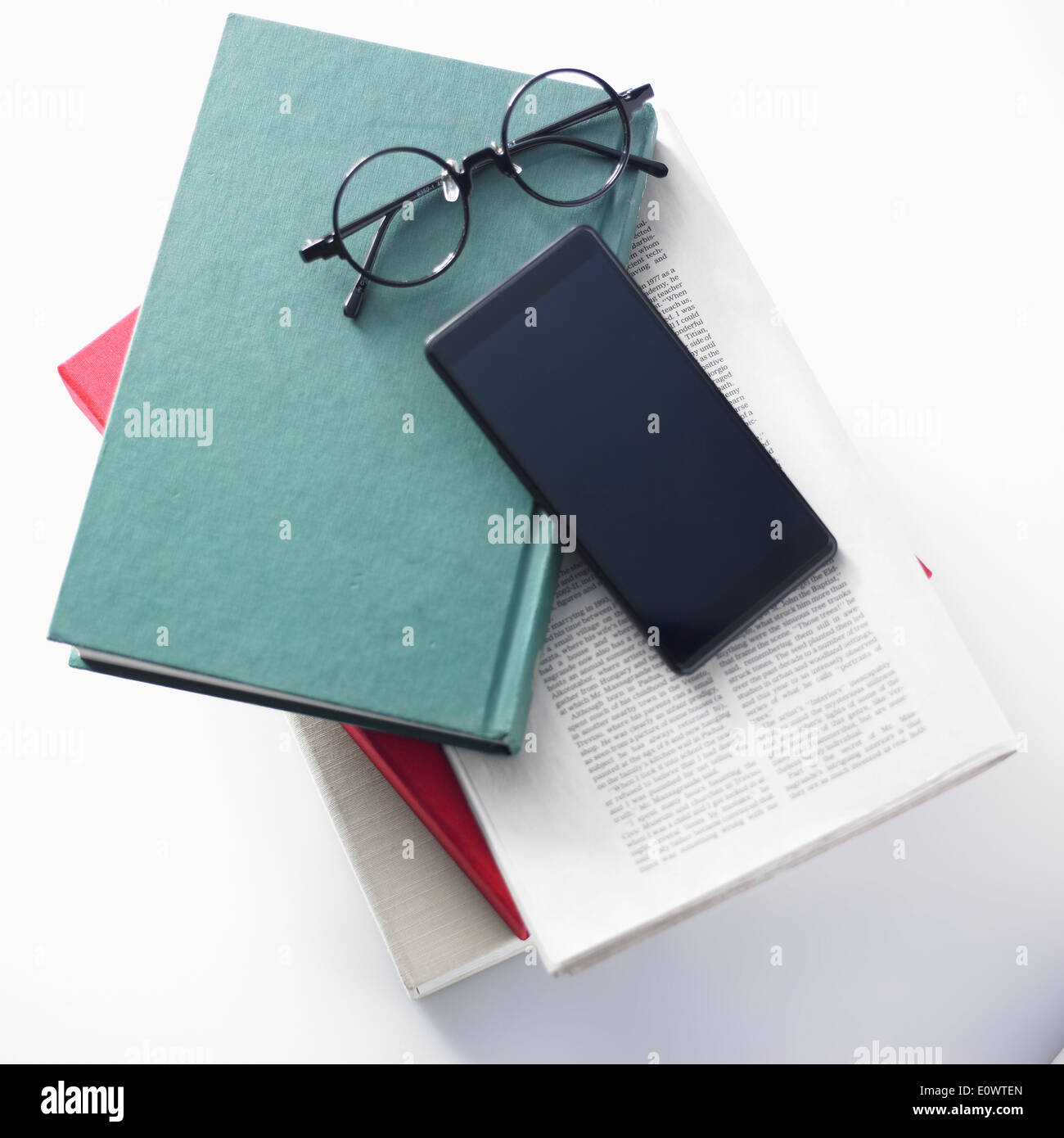 eine Reihe von Bücher unter ein smart Phone und Gläser Stockfoto