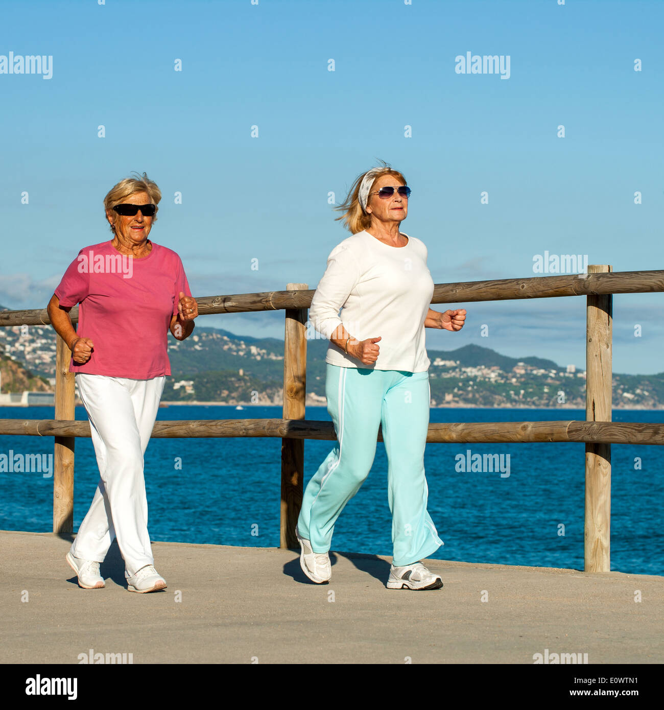 Seniorenfitness Frauen zusammen am Strand joggen. Stockfoto
