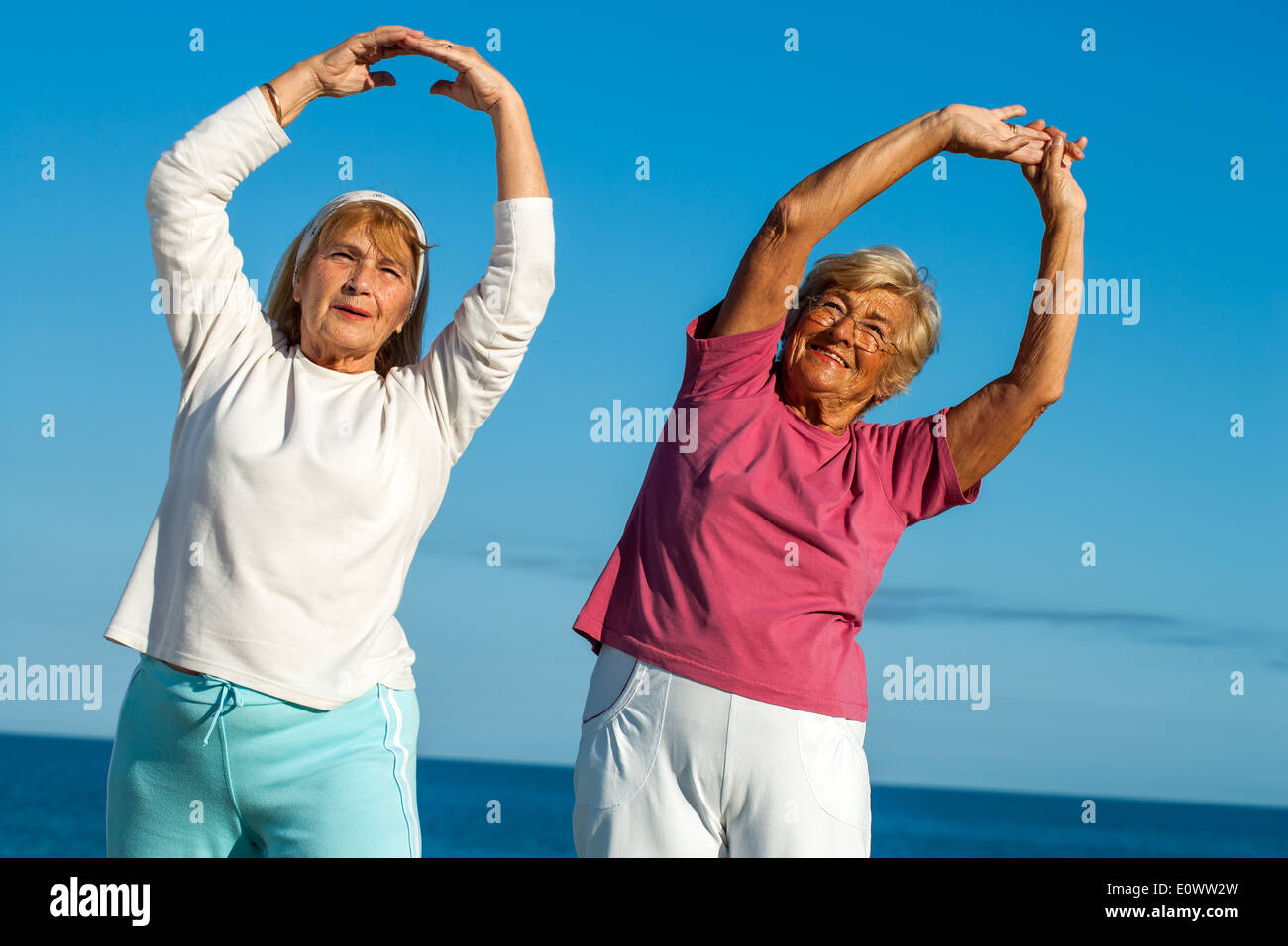 Porträt von zwei Seniorenfitness Damen Strecken Arme im Freien. Stockfoto