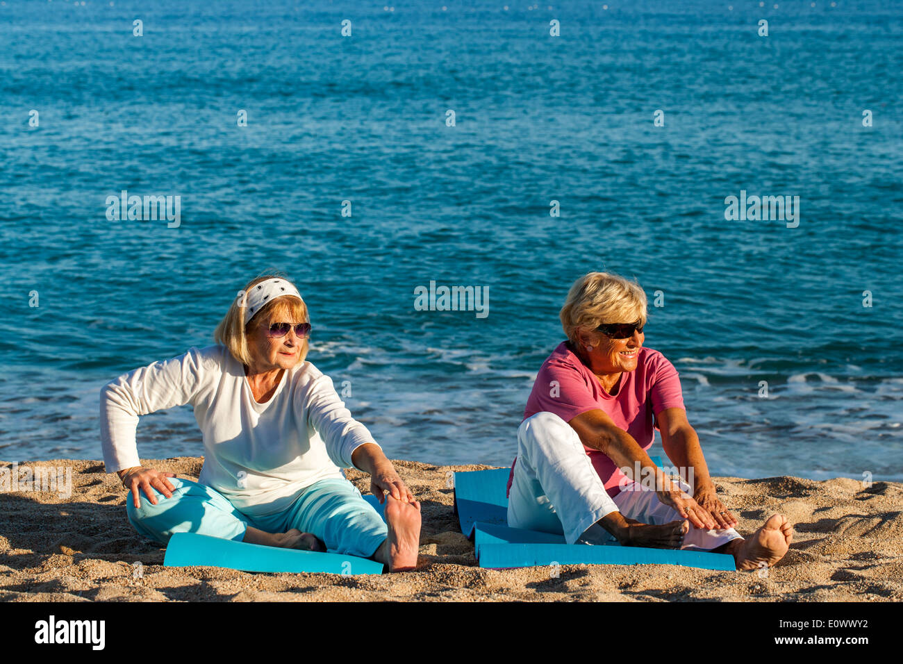 Zwei ältere Damen stretching-Übungen am Strand zu tun. Stockfoto