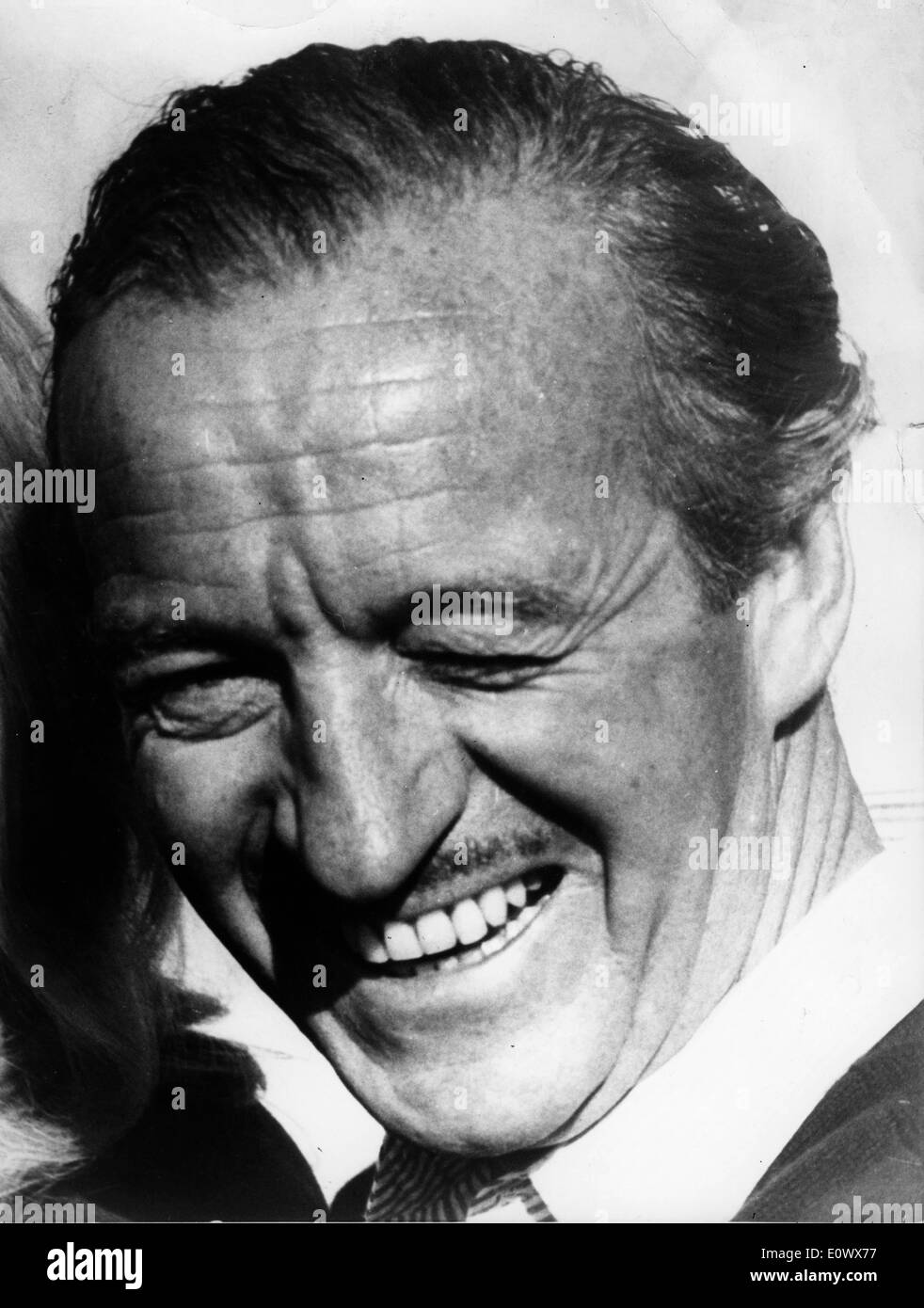 Schauspieler David Niven schielt von der hellen Sonne Stockfoto