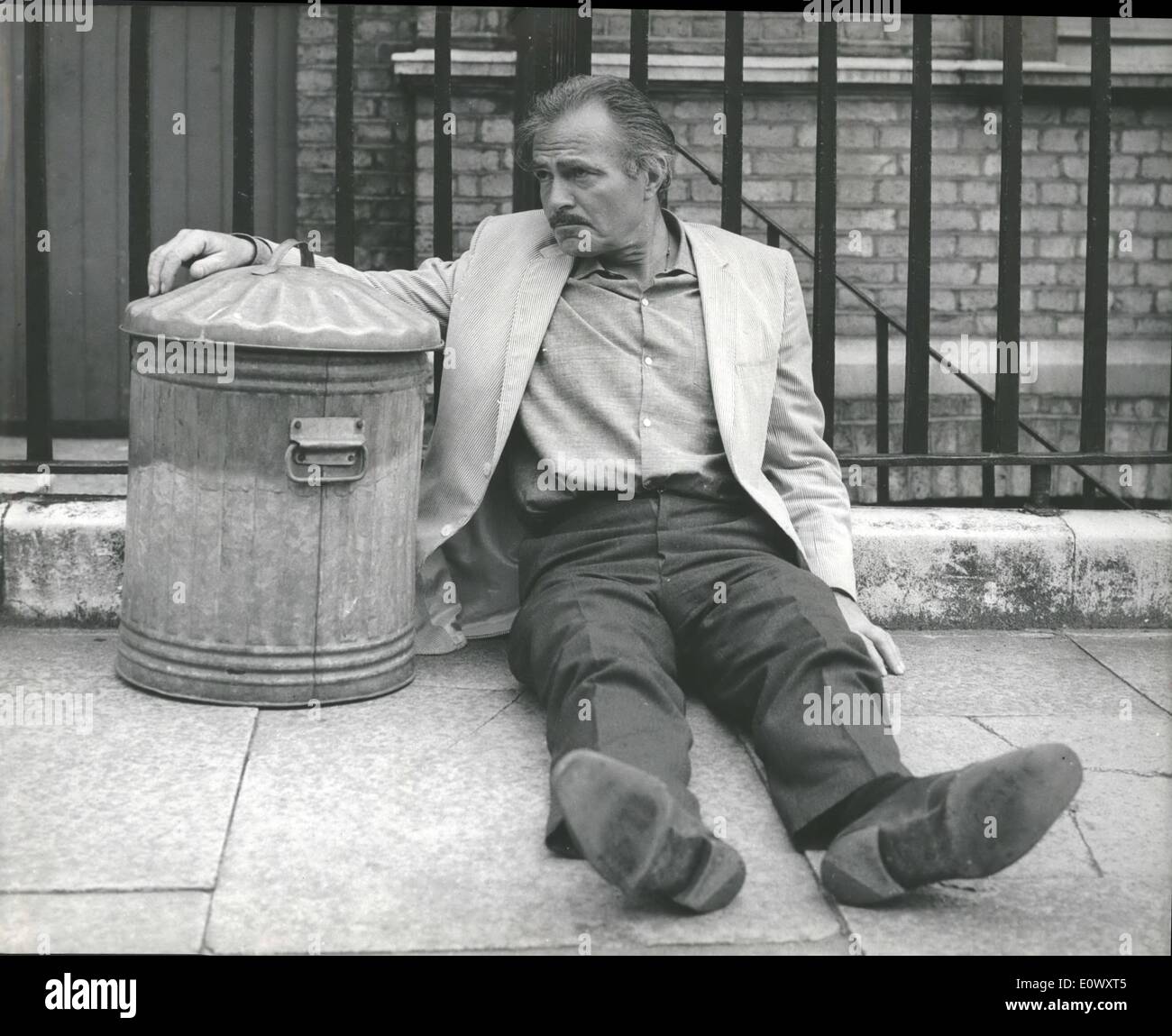 6. Juni 1964 - James Mason in Fernsehspiel angezeigt werden. James Mason, einer der weltweit führenden und umstrittensten Filmstars, macht seine ersten unabhängigen Fernsehauftritt Drama und seine Uraufführung des Dramas in Großbritannien seit dem Krieg im Associated Television '' A Tall tapferen Lancer'', Proben für die heute begann. Foto zeigt: James Mason sitzt auf dem Bürgersteig neben einer Mülltonne während der Proben heute Morgen. Stockfoto