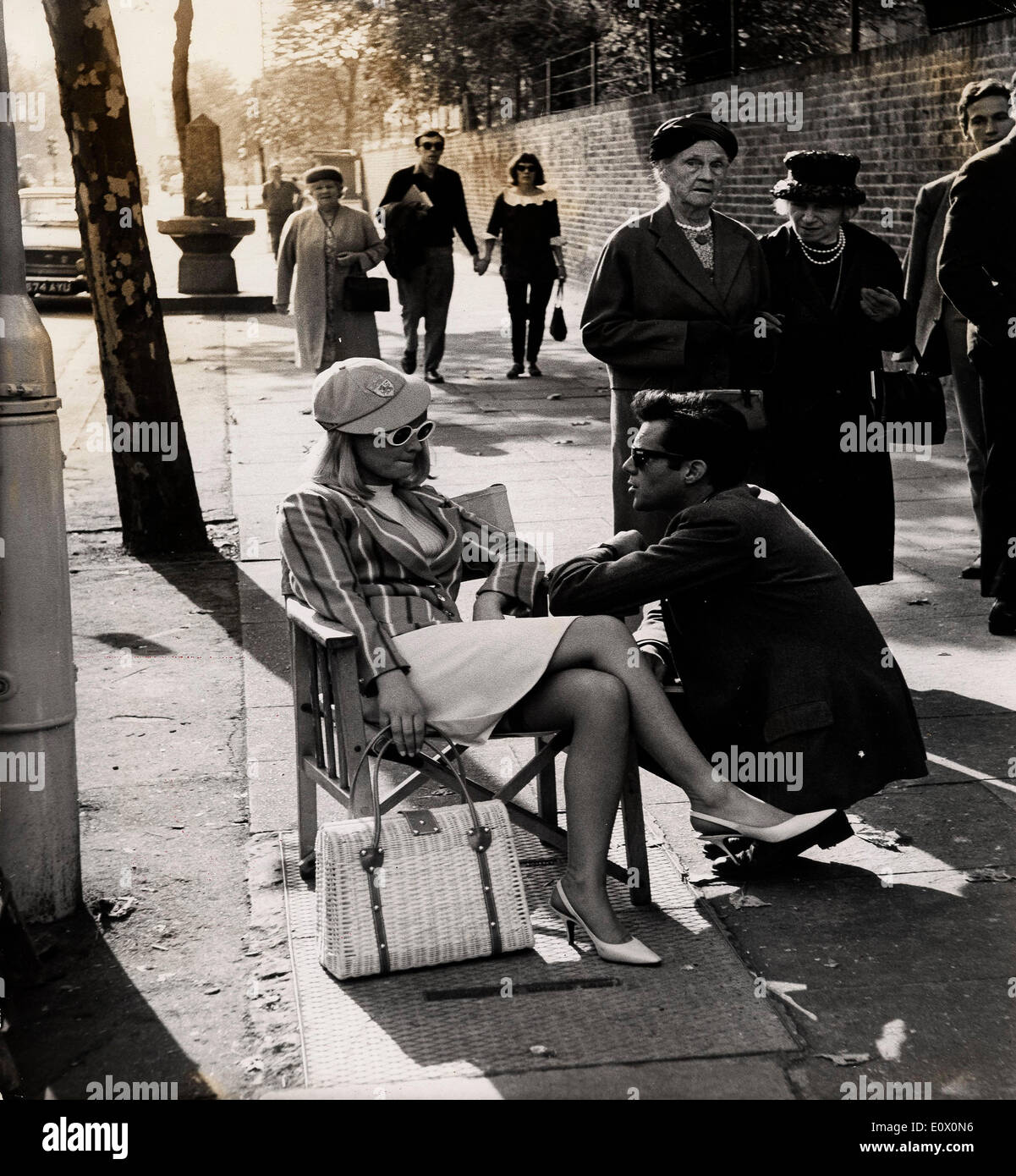 Sep 29, 1964 - London, England, Vereinigtes Königreich - schöne Julie Christie, die für Ruhm mit einer Reihe von Kleinteilen in Filmen - präpariert worden war gestern gesehen ab Werk auf ihre erste Hauptrolle sein. Es ist gegenüber Dirk Bogarde und Laurence Harvey und der Film mit dem Titel "Darling". Die Szene war eine Warteschlange für ein Testspiel außerhalb Lords - in denen sie mit 200 Extras für das Spiel in die Warteschlange. Auf diesem Foto, JULIE CHRISTIE - cap trägt ein rosa Cricket und gestreiften Cricket Blazer - spricht mit DIRK BOGARDE - zwischen Dreharbeiten außerhalb Lords gestern. Stockfoto