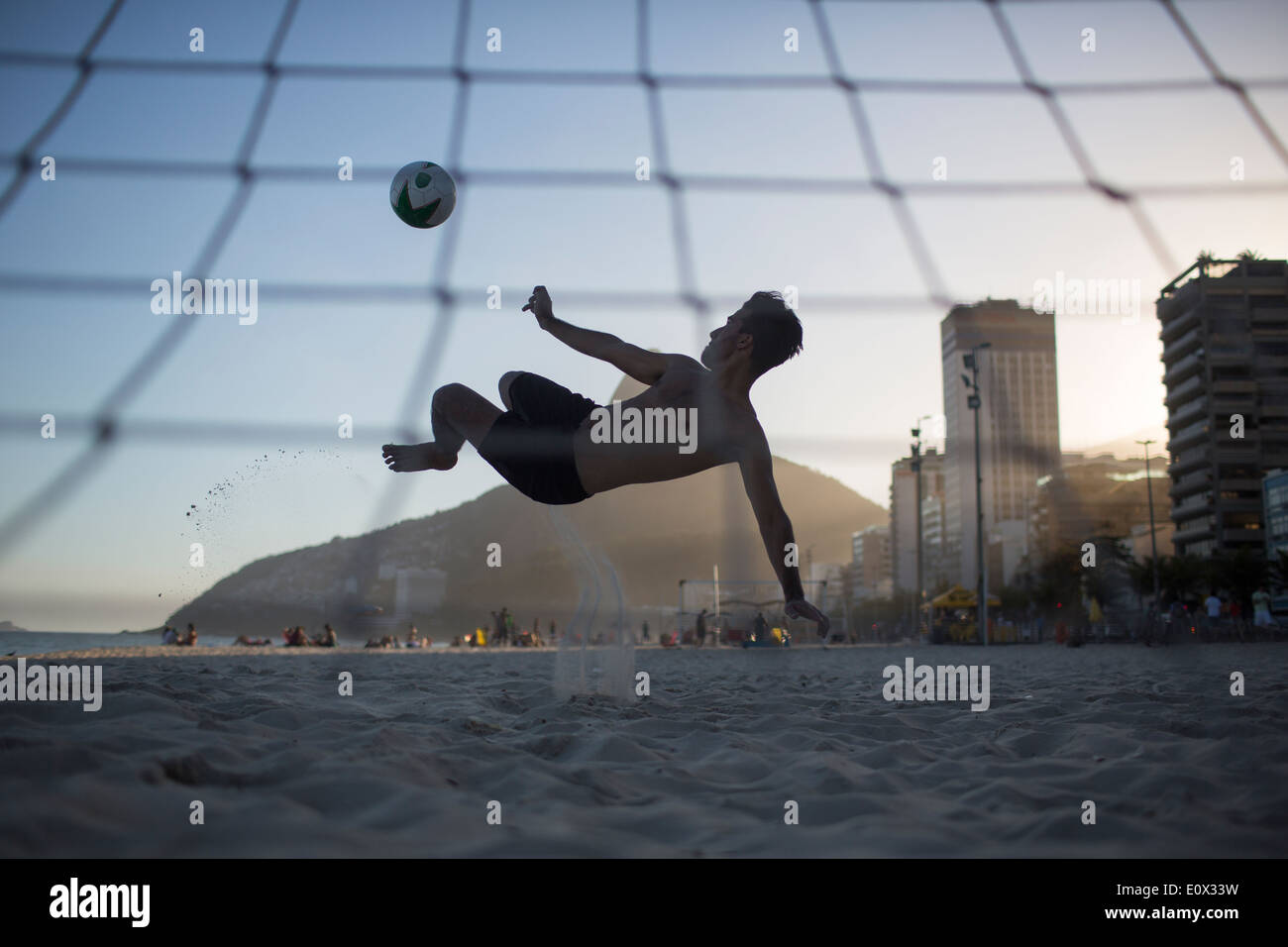Ein Fußballer erzielt akrobatisch ein Tor aus einem Bicyclette Overhead Fußball Kick am Strand von Ipanema in Rio De Janeiro, Brasilien Stockfoto