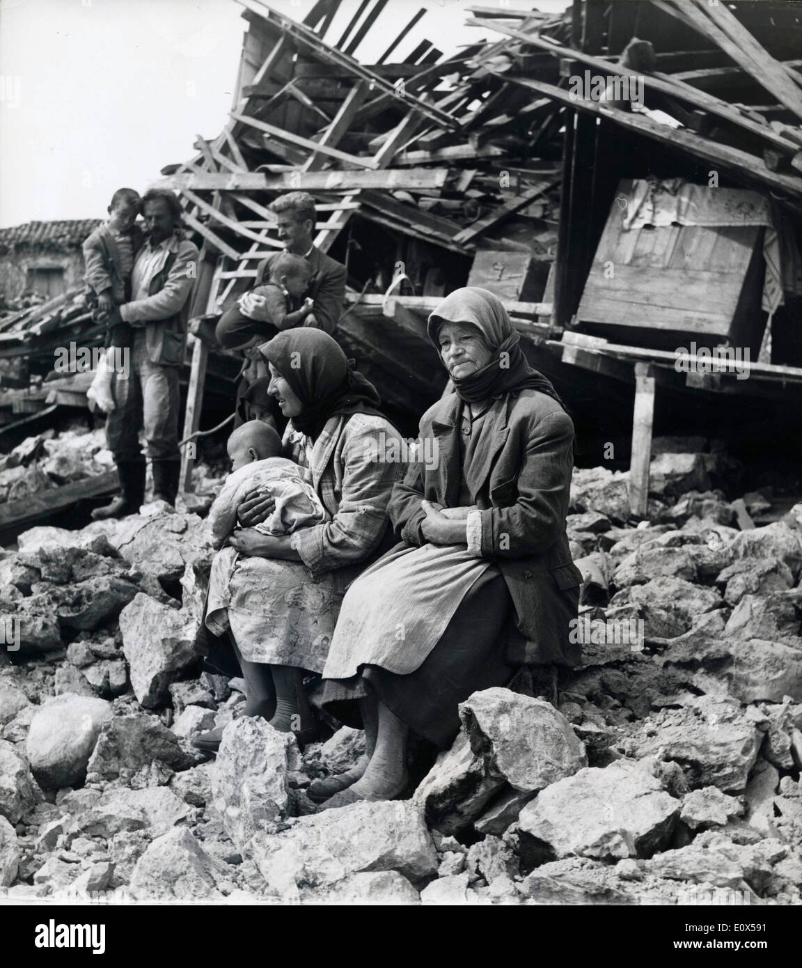 Datei Foto - 7. April 1965 - Peloponnisos, Griechenland - eine Familie sitzt inmitten der Ruinen ihres Hauses im Bereich Megalopolis desolate nach dem Erdbeben der Stärke 6,2-Peloponnisos, das 32 getötet und Hunderte verletzt. Stockfoto