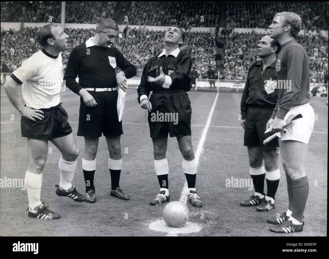 7. Juli 1966 - World Cup Fußball England Versus Deutschland Welt-Cup-Finale in Wembley Foto zeigt:-Schiedsrichter Gottfried Dienst wirft die Münze vor Beginn des Marsches beobachtet von Uwe Seeler der deutsche Kapitän (links) und Bobby Moore, Kapitän der englischen Nationalmannschaft (rechts) Stockfoto
