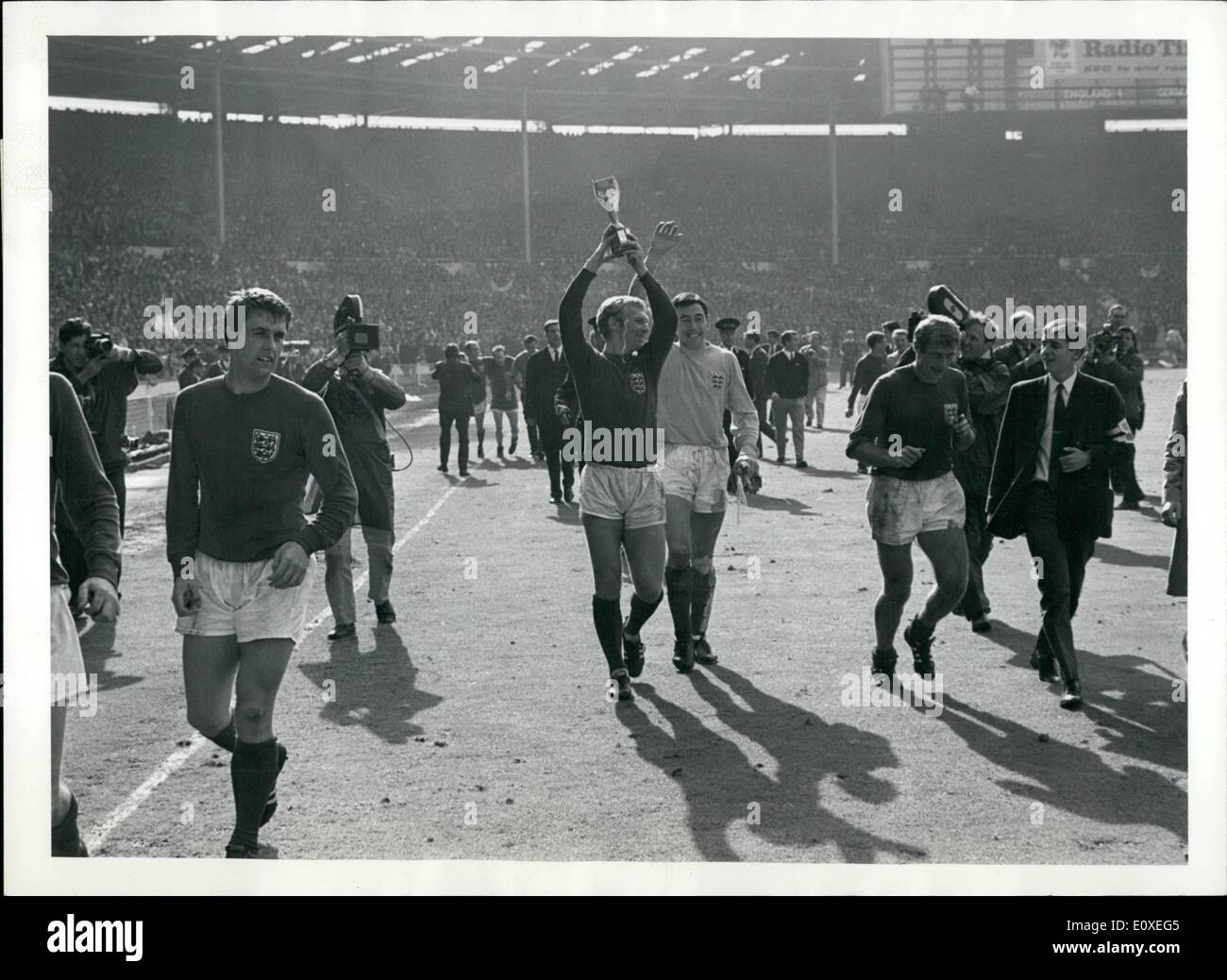 7. Juli 1966 - Fußballweltmeisterschaft 1966. Die endgültige England V. Westdeutschland im Wembley-Stadion. England gewann 4-2 nach zusätzlichen Zeit.: Bobby Moore (Englands Kapitän) führt sein Team rund um das Spielfeld Wembley nach Englands WM-Finale Sieg gegen die Bundesrepublik Deutschland. Stockfoto