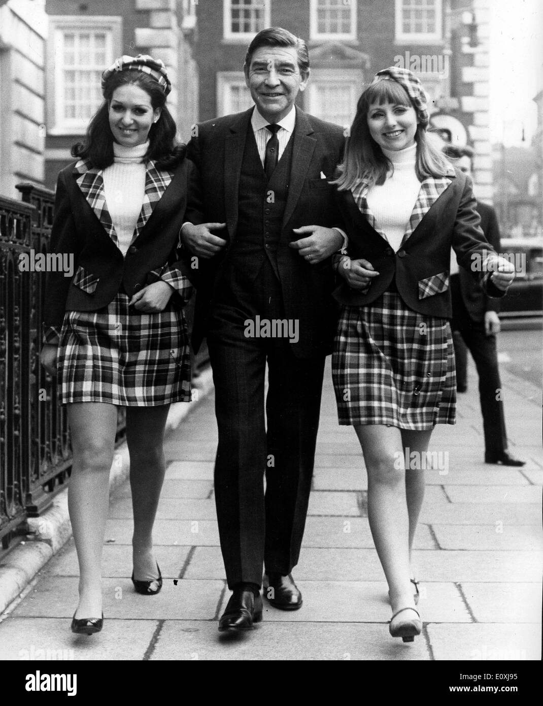 Schauspieler Robert Beatty auf einem Spaziergang mit zwei Modellen in London Stockfoto