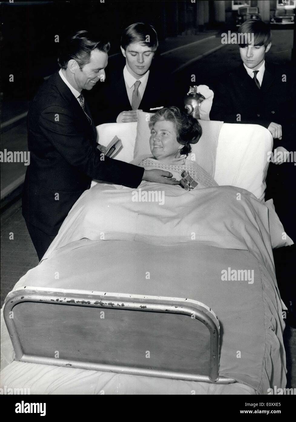 12. März 1968 - März 12, 1968 Frau Doris Page erhält der MBE. Frau Doris Page, 42, ist abgebildet in einem Bett in das Viereck des Buckingham Palace heute, zeigt ihr Mann Kenneth und ihre beiden Söhne, Brian 17 und Andrew 15, MBE, ihr von Königin Elizabeth II geschenkt wurde. Mrs-Page von Essex Street, Newbury, Berkshire, England, ist ein Polio-Opfer und nutzt eine eiserne Lunge, erhalten ihre Auszeichnung für ihre Arbeit als Herausgeber der Zeitschrift Responaut für Menschen, die Leben von Atemschutzgeräten. Stockfoto