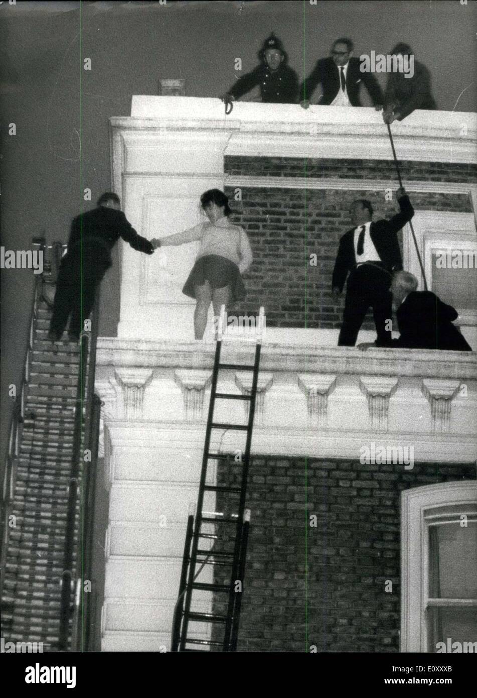 27. März 1968 - Mädchen im Drama auf Felsvorsprung. 22-jährige Marie Mullally, Zimmermädchen, stand für drei Stunden gestern auf einer schmalen 4. Etage Sims 60 Fuß über dem Boden in einem Park Royal Hotel in Kensington, und drohte zu springen. Ein Feuerwehrmann auf einer Drehscheibe schließlich packte sie und trug sie schreien und kämpfen, um den Boden. Foto zeigt: Dies war die Szene auf dem Sims als Retter versuchen, das Mädchen aus dem Sims zu hieven. während der gestrigen Drama hoch über dem Boden. Stockfoto