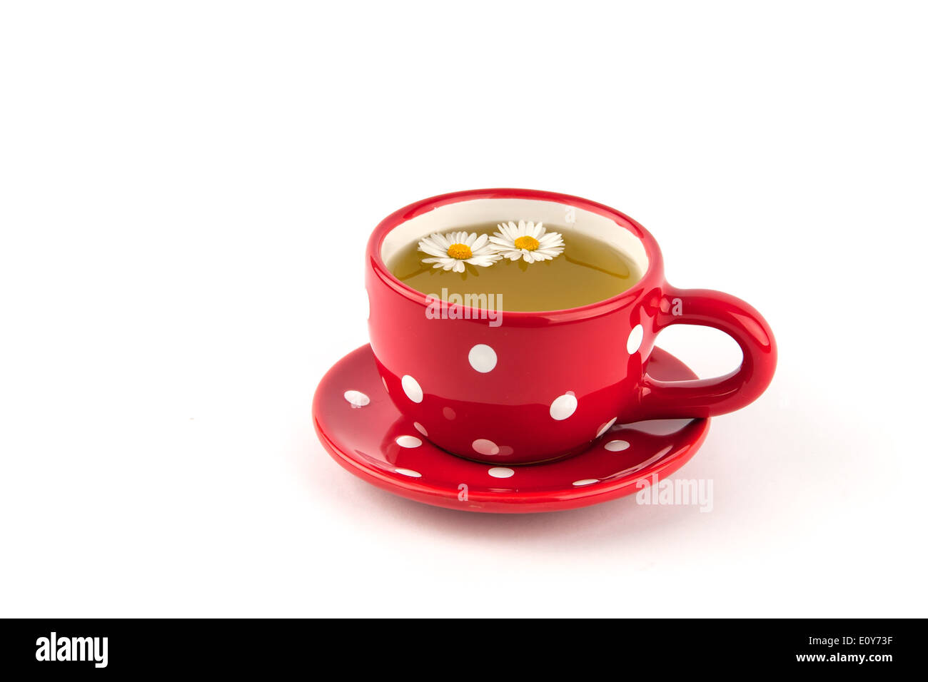 Kamillentee in gepunktete rote Tasse mit Blume Stockfoto