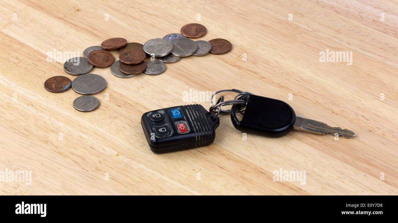 Eine Reihe von Autoschlüsseln mit Kleingeld auf ein Holz Arbeitsplatte. Stockfoto