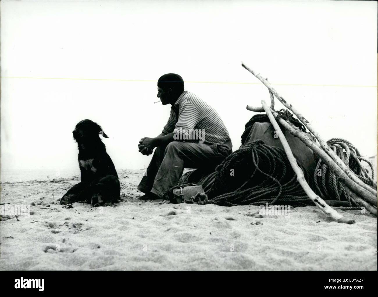 19. Juni 1969 - erfreuen sich dieses Paar Mann und des Mannes bester Freund Morgen Ruhe an einem Strand im Süden von Frankreich. Das Gebiet wurde von Touristen in dieser Zeit besiedelt. Stockfoto