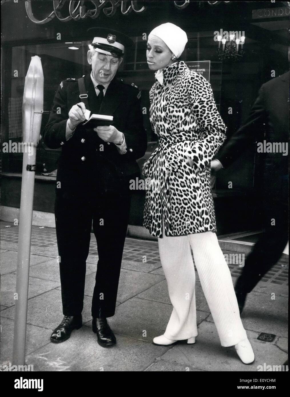 11. November 1969 - bekommt gebucht - sie ein TICKET. HELGA BRAUCKMEYER, die Christian Dior Paris Fell Sammlung Modellierung wurde, sieht nicht allzu erfreut, als sie sieht ein Traffic Warden ihr ein Ticket geben. Sie trägt einen Mantel in '' Somalia Panther " Stockfoto