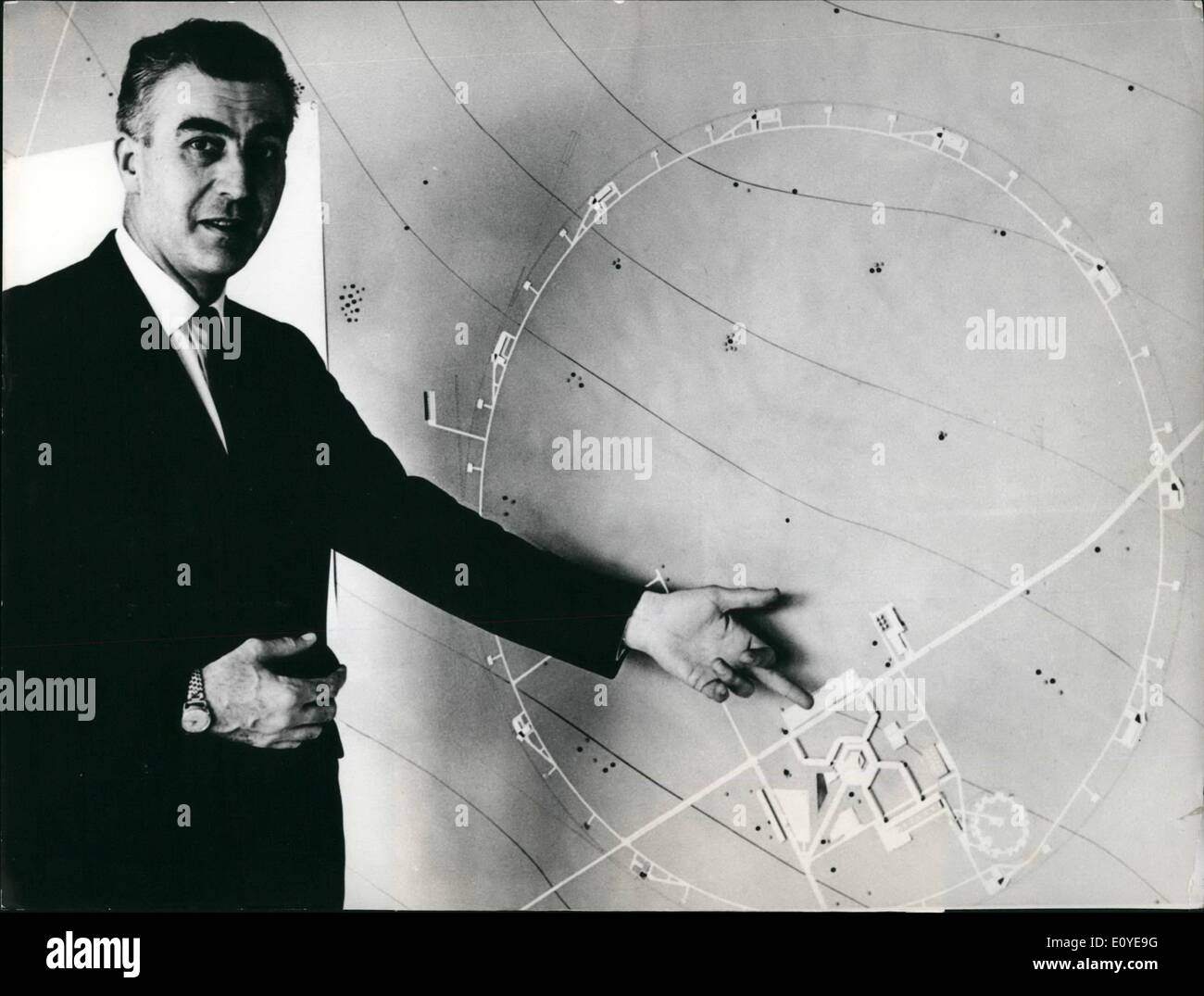 1. Januar 1970 - '' Supercern'' - 300 Milliarden Volt-Projekt: John B. Adams, Direktor des 300 GeV-Beschleuniger-Projekts, fotografiert vor einem Modell eines möglichen Layouts die gigantische Maschine. Stockfoto