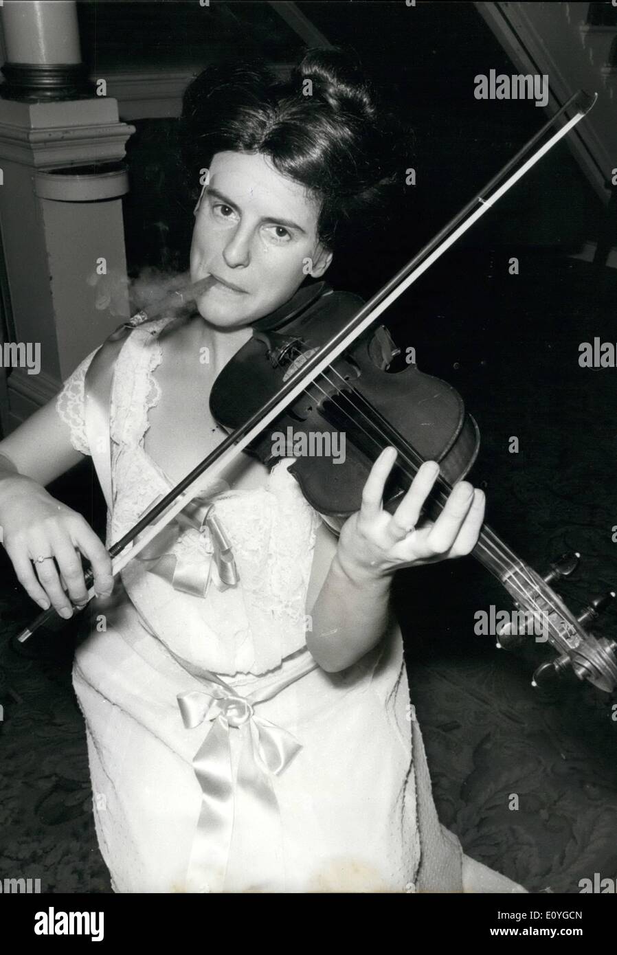 4. April 1970 - ein Damen-BAND für die neue Oper "Sieg" in COVENT GARDEN. Die Besetzung für Rodneys neue Oper ''' Sieg '' enthält eine Damen-Band sieben jungen Damen, die auf der Bühne spielen erscheinen Singspiel getroffen Melodien der 1890 in einem heruntergekommenen Hotel in Niederländisch-Ostindien. die neue Oper '' VICTORY'' feiert seine Weltpremiere am Royal Opera House. Covent Garden am 13. April. Foto zeigt: JOYCE NIXON, aus Dundee, spielt die Geige in der Damen-Band, wer genießt, eine Zigarre rauchend, paffte, wie sie für die heutige Generalprobe am Royal Opera House von Tunes gesehen. Stockfoto