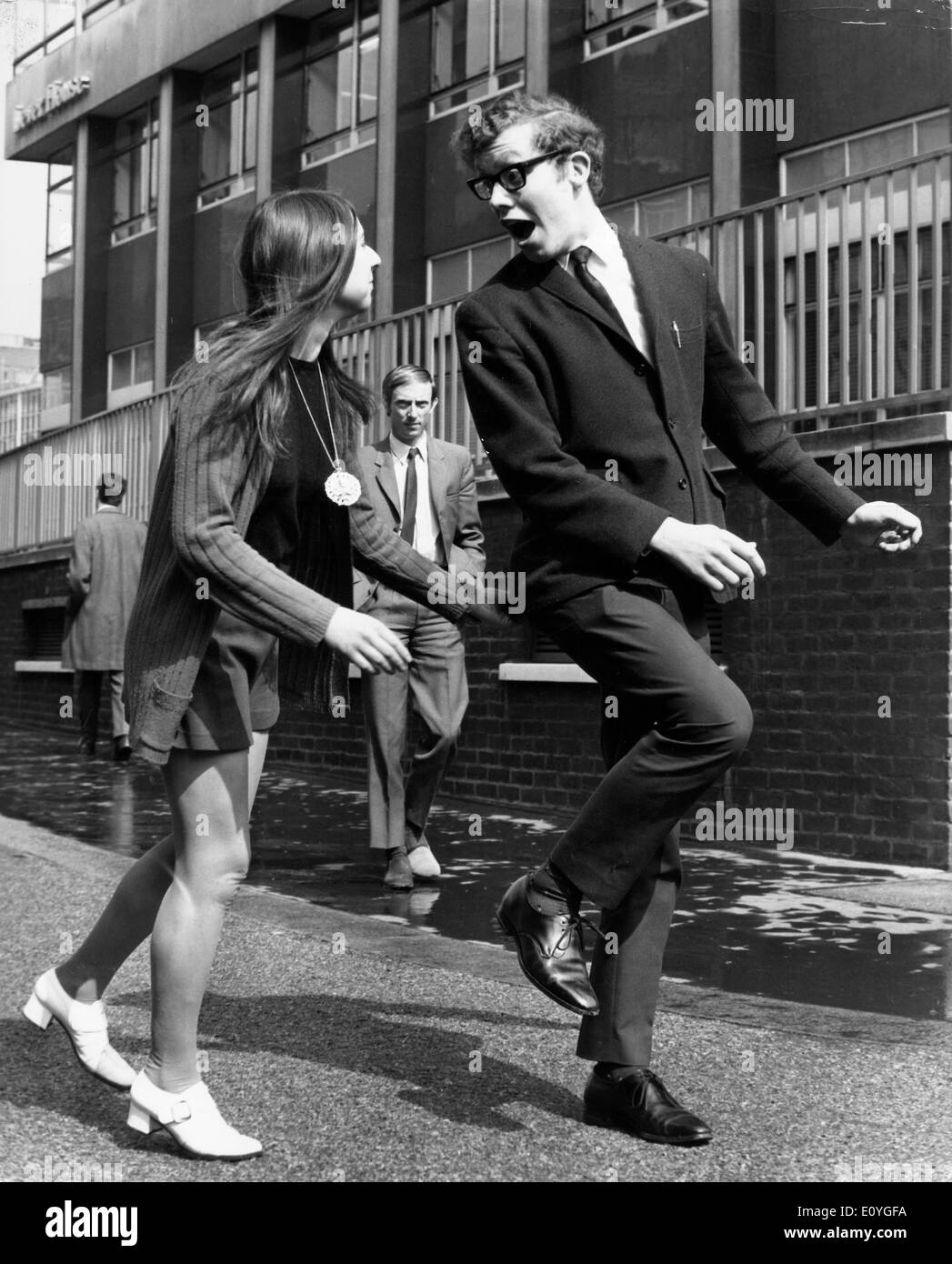 10. April 1970; London, England, Vereinigtes Königreich; Eine junge Frau drückt eine junge mans unten. Stockfoto