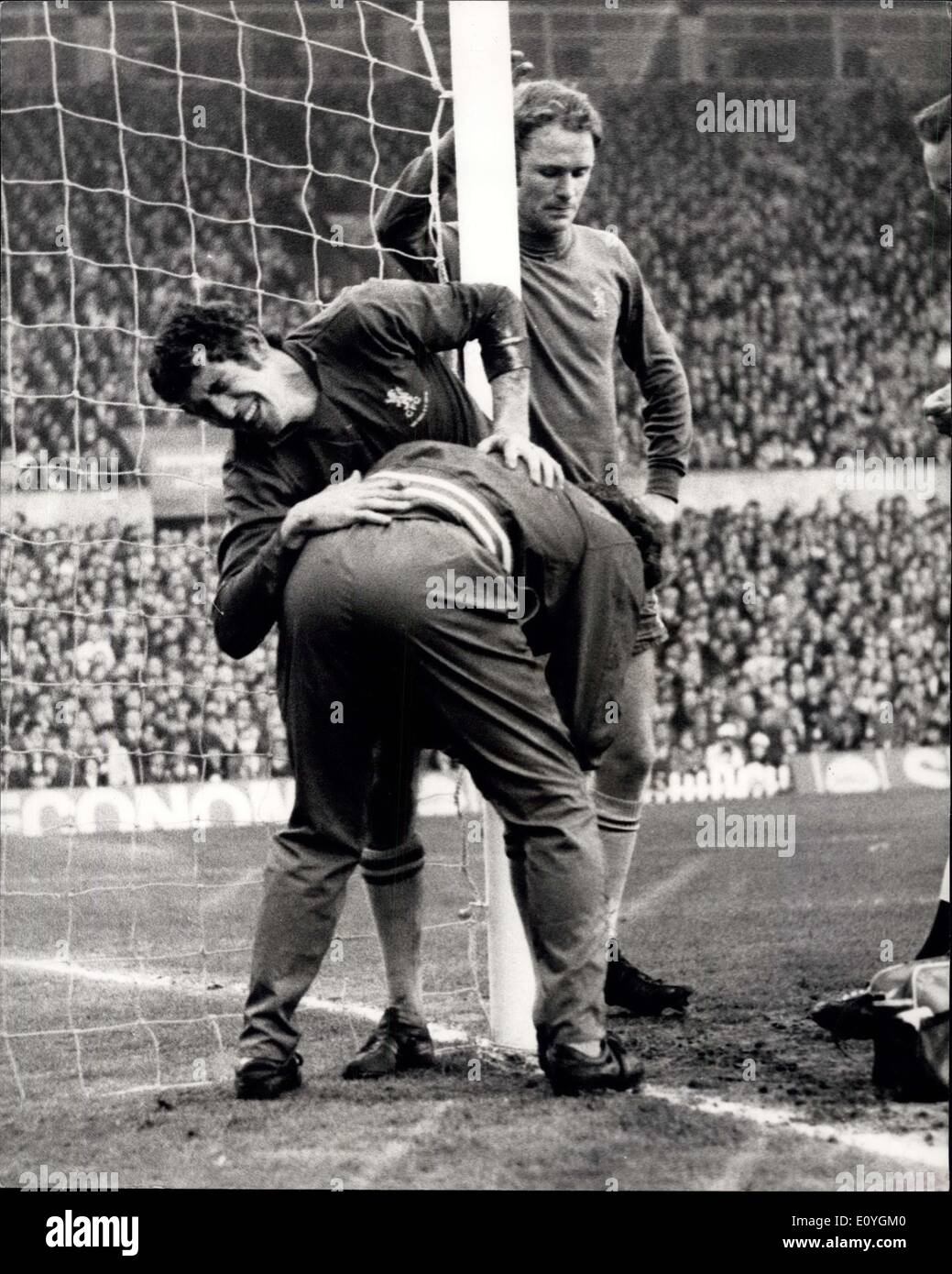 30. April 1970 - Chelsea gewinnen die F.A. Cup: Foto zeigt Peter Bonnetti, der Chelsea-Torhüter sein Gesicht vor Schmerz verdreht, Behandlung von Chelsea-Trainer Harry Medhurst, beobachtet von einem ernsten Gesicht Mitspieler, John Dempsey erhält. Bonetti wurde verletzt, als er für eine hohe Zentrum mit Jones - während der letzten Nacht F.A.-Cup-Finale Wiedergabe im Old Trafford, Manchester ging die Chelsea 2: 1 gewonnen. Stockfoto