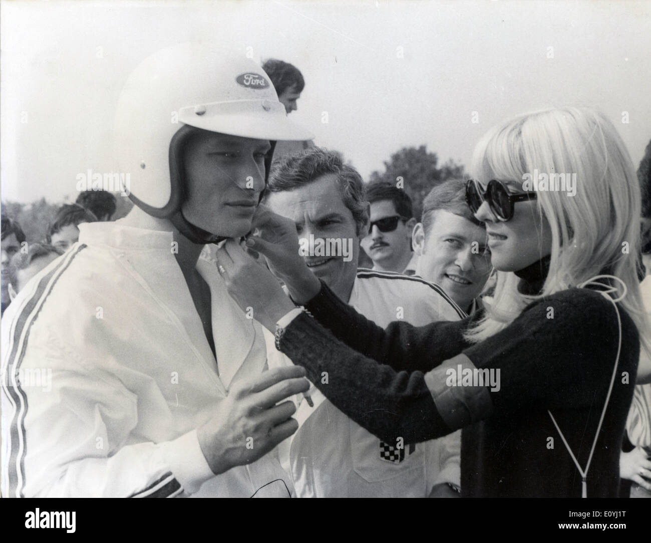15. Juni 1970 - Montlhery, Frankreich - JOHNNY HALLYDAY bekommt Hilfe seinen Helm von seiner Frau SYLVIE VARTAN vor dem Start des Rennens ACJF Cup sichern. Genaues Datum unbekannt. Stockfoto