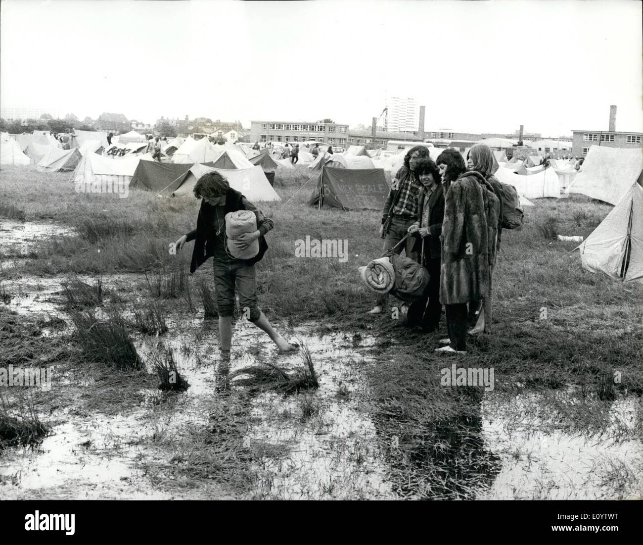 6. Juni 1971 - Hippie "Polizei beschlagnahmt 100 Pop-Fans bei einem Pop-Festival in Reading. : Detektive im Hippie-Gang durchsucht Hunderte von Jugendlichen für Drogen beim Lesen Pop Festival gestern, und mehr als 100 Fans wurden verhaftet. Es wurde geschätzt, dass einige 20.000 Fans besucht, viele von ihnen ganze Nacht trotz des starken Regens lagerten. Foto zeigt einige der Fans waten durch einen regen sodden Feld auf der Suche nach ein trockenen Plätzchen zum Camp. Stockfoto