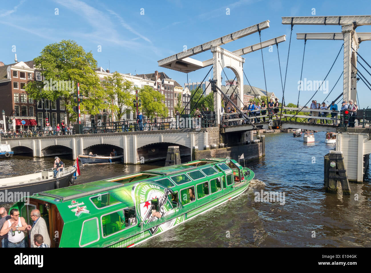 Amsterdam-Heineken Shuttle Grachtenfahrt Boot mit Magere Brug, magere Brücke auf dem Fluss Amstel Kanal mit kleinen Booten Stockfoto