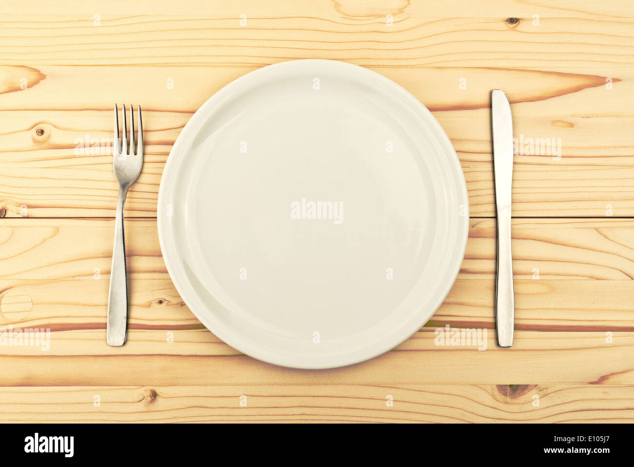 Leerraum Platte auf Holztisch mit Messer und Gabel als Konzept für Hunger und Fütterung, auch eine Kopie für Ihren Text oder Design. Stockfoto