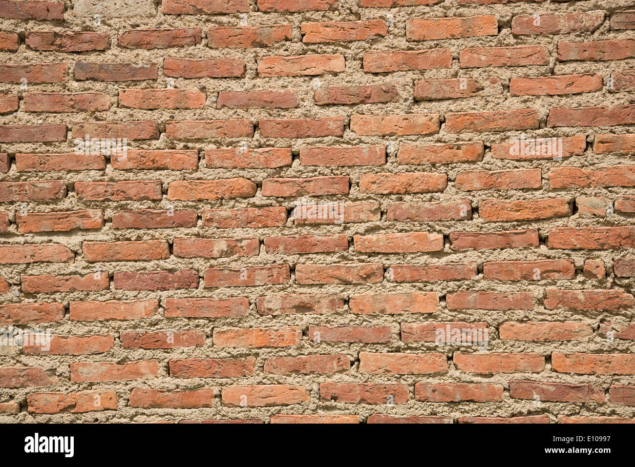 Mauer aus dünnen handgefertigten roten Lehmziegeln gemacht Stockfoto