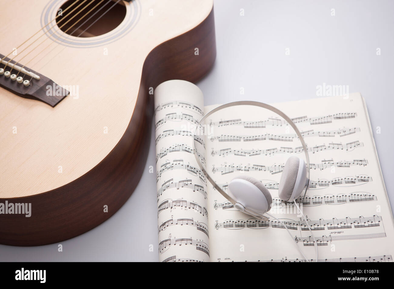 ein Kopf auf einem Notizbuch neben einer akustischen Gitarre gesetzt Stockfoto