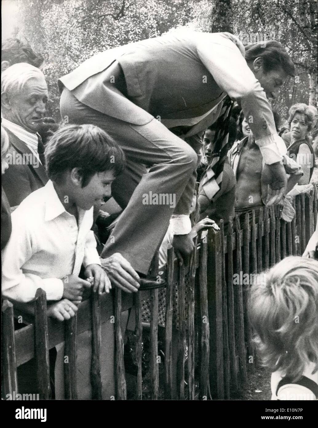 7. Juli 1973 - (James Bond) Roger Moore springt einen Zaun zum Schutz von Fans zu einem Lambeth Charity Fete zu entkommen: 007 Roger Moore hat einen eiligen Rückzug durch einen Zaun zu springen, wenn er von begeisterten Fans, beim Öffnen der Silver Jubilee-Fete der South London Familie Serviceeinheit am Myatts Field, Lambeth, London, heute gemobbt wurde zu schlagen. Nach den Zaun springen machte er für sein Auto für einen Kurzurlaub. Foto zeigt, dass Roger Moore als er über den Zaun springt nach Glaubensbekennenden Fans bei der Fete heute angesehen wird. Stockfoto