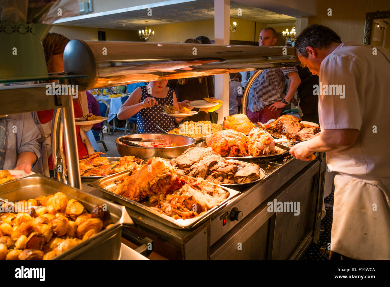 Ein Chefkoch am Arbeitsplatz schnitzen Gelenke von Fleisch auf einen Sonntag Mittagessen Abendessen Buffet in einem UK-Hotel-restaurant Stockfoto