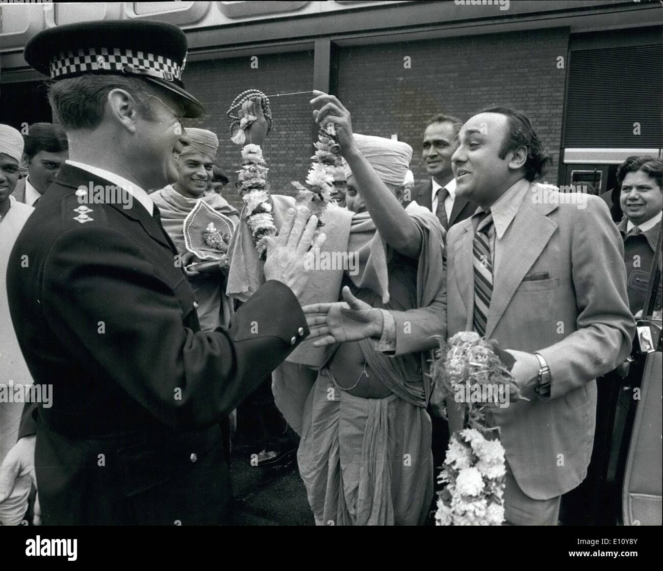 6. Juni 1974 - Polizisten Widerstand zu überwinden durch hinduistische Flower Power: Polizei-Inspektor Rawlinson zunächst höflich lehnte das Angebot von einem Kranz von h.s. göttlichen Heiligkeit Shree Pramukh Swami Shree Narayanswarupdasji, spiritueller Leiter der Shree Swaminarryan Hindu Mission, als er am Flughafen Heathrow am Samstag für eine Tour durch Großbritannien ankam. Aber dann der Prüfer seine Meinung geändert und akzeptiert. Stockfoto