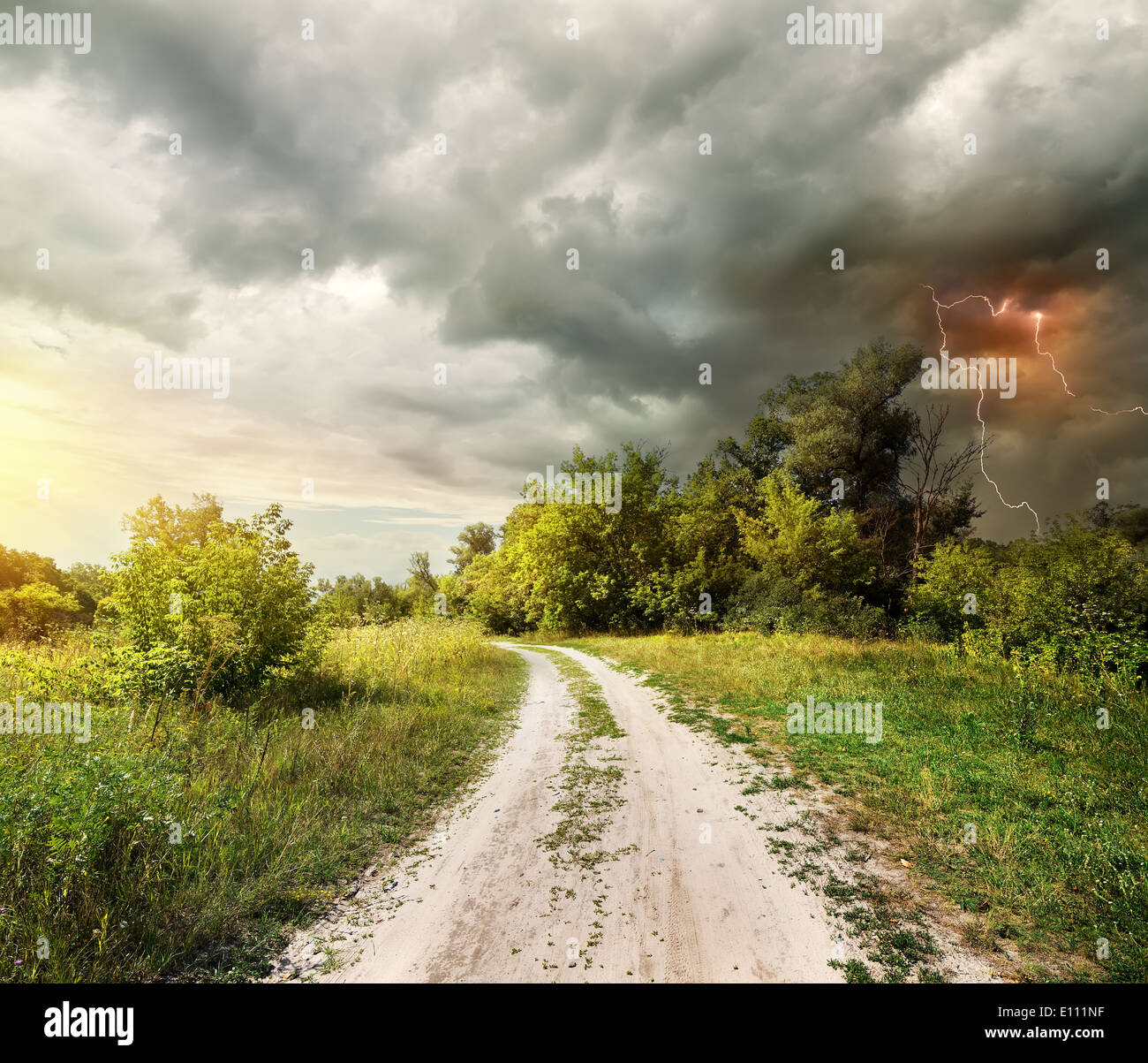 Landstraße durch den Wald und Blitz Stockfoto